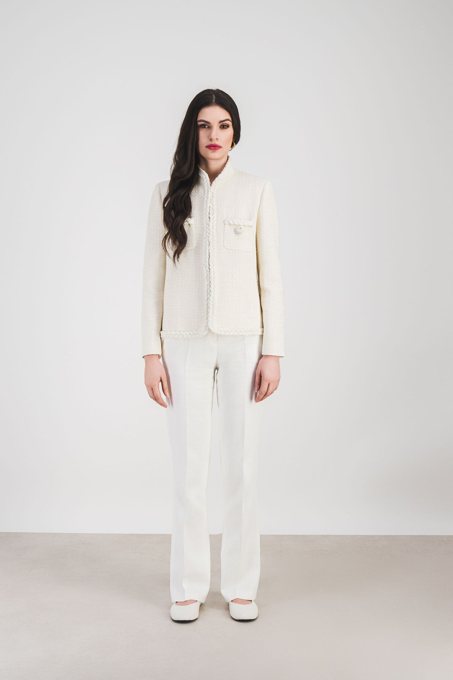 Veste en tweed blanc à col officier. Son design structuré et ses détails soignés.