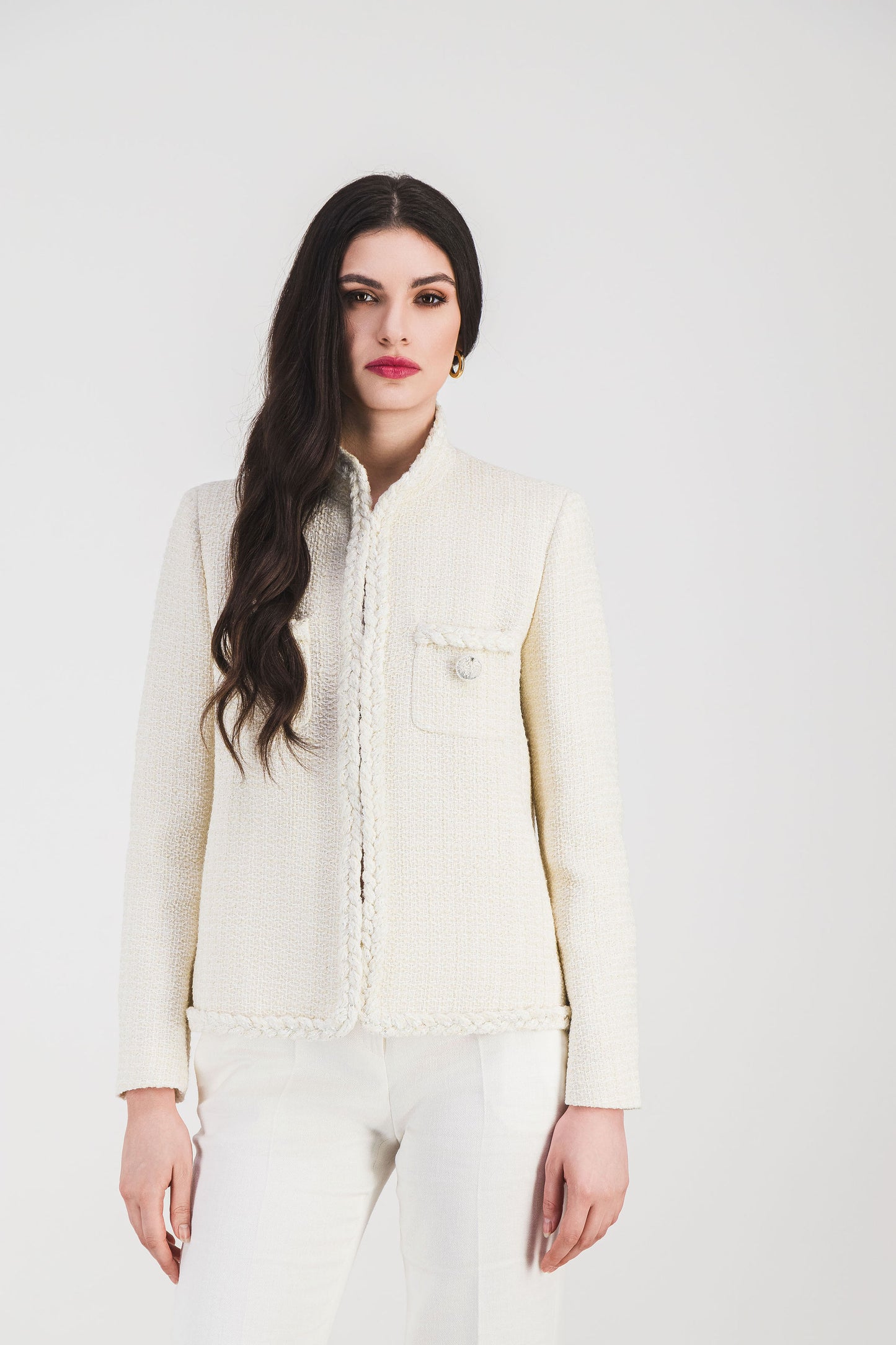 La veste en tweed blanc apporte une allure chic grâce son col officier et sa coupe structurée.