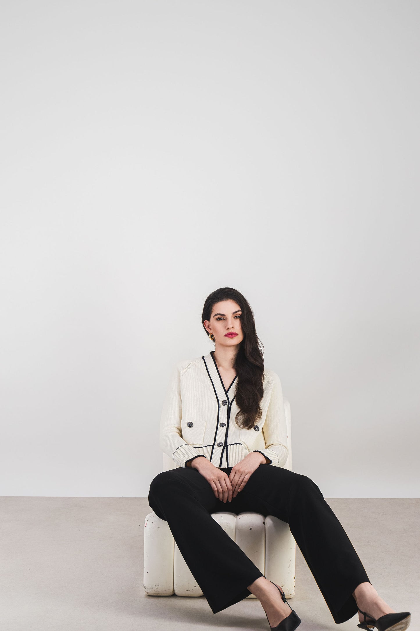 Ce gilet blanc cassé bicolore en coton bio, avec col V et boutons métalliques, allie praticité et élégance casual chic.