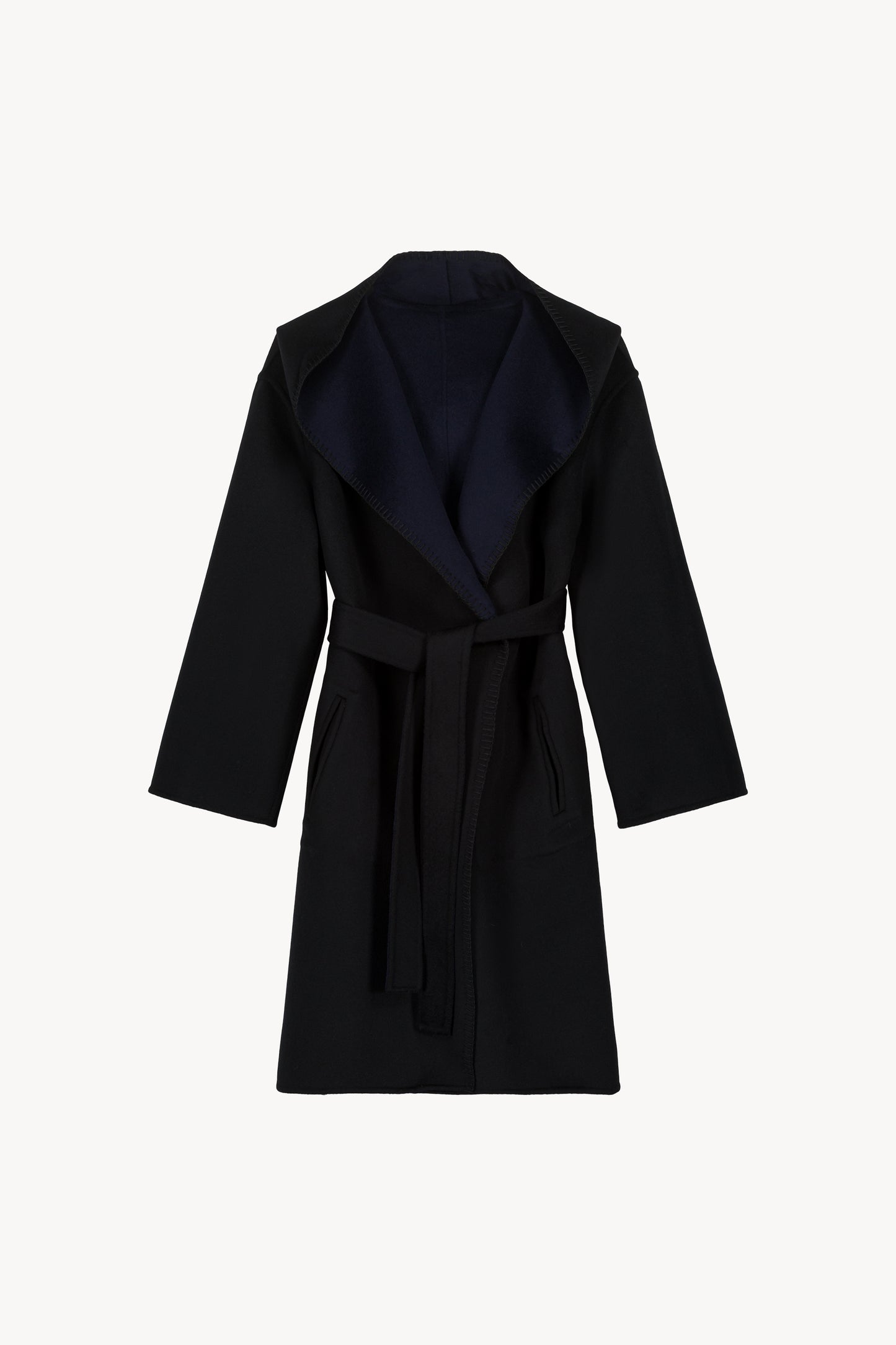 Manteau oversize réversible noir et marine. Col tailleur, capuche intégrée. Finitions à points feston faits main. Ceinture ton sur ton et poches plaquées sur chaque face.