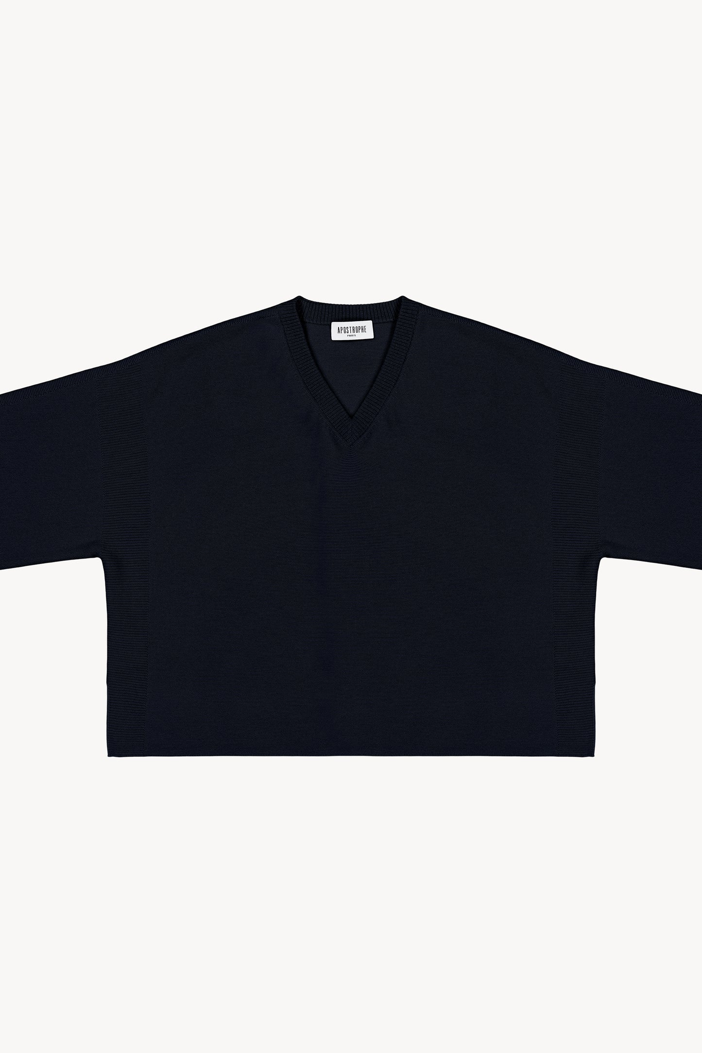 Ce pull oversize en laine à col V, avec ses manches 3/4 et ses détails lurex au col, offre une silhouette fluide.