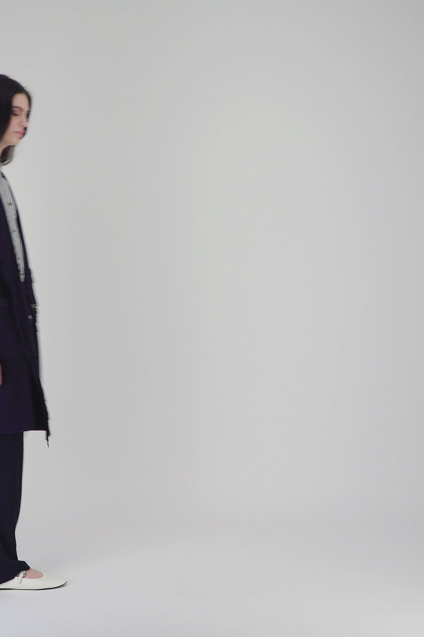 Manteau long mi-cuisse avec franges en daim et col drapé fluide pour une allure élégante en hiver.