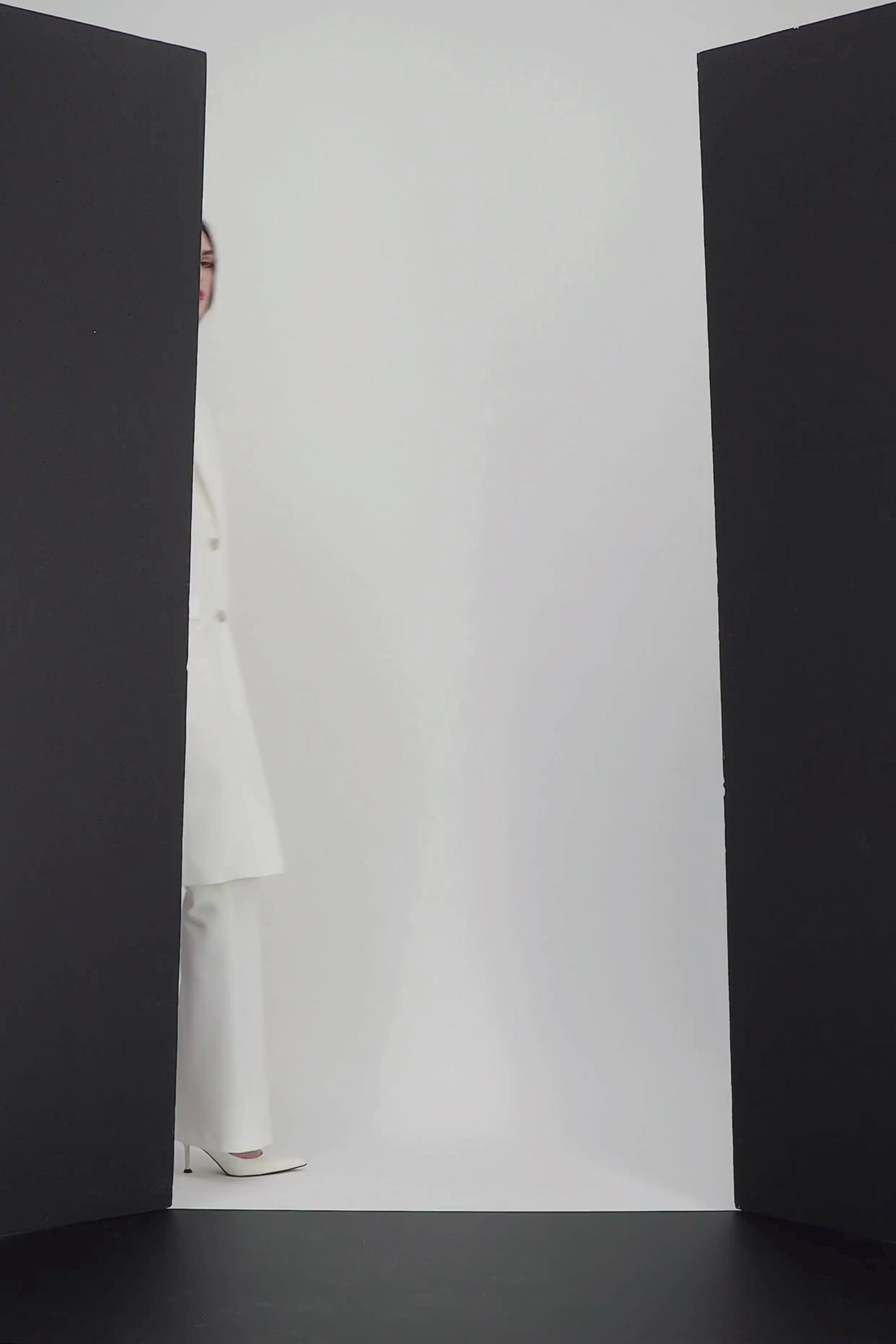 Manteau raffiné en blanc, avec col tailleur distinctif et poches passepoilées. Un modèle structuré.