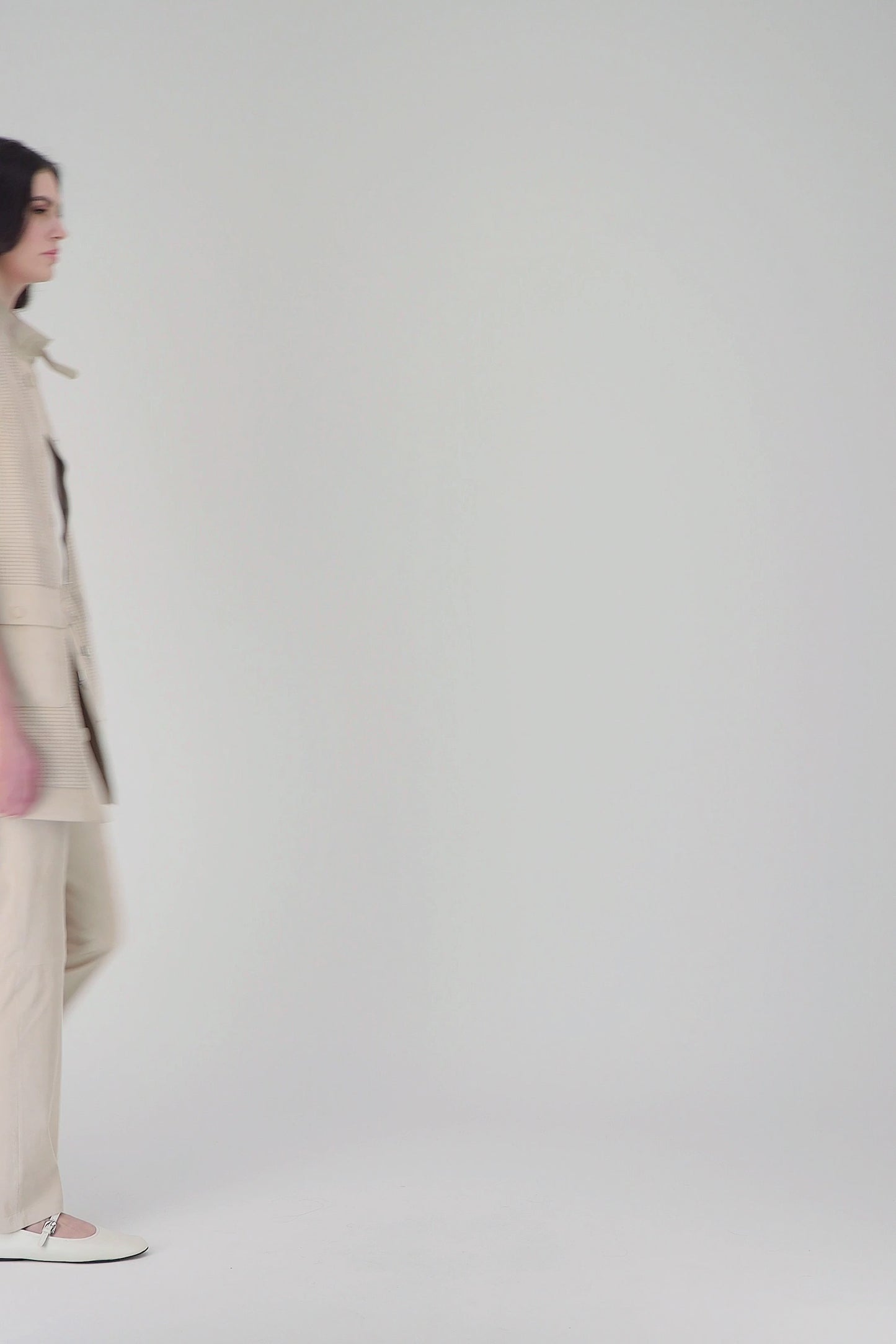 Veste mi-longue en daim beige clair, avec perforations et poches plaquées, idéale pour un look moderne et pratique.
