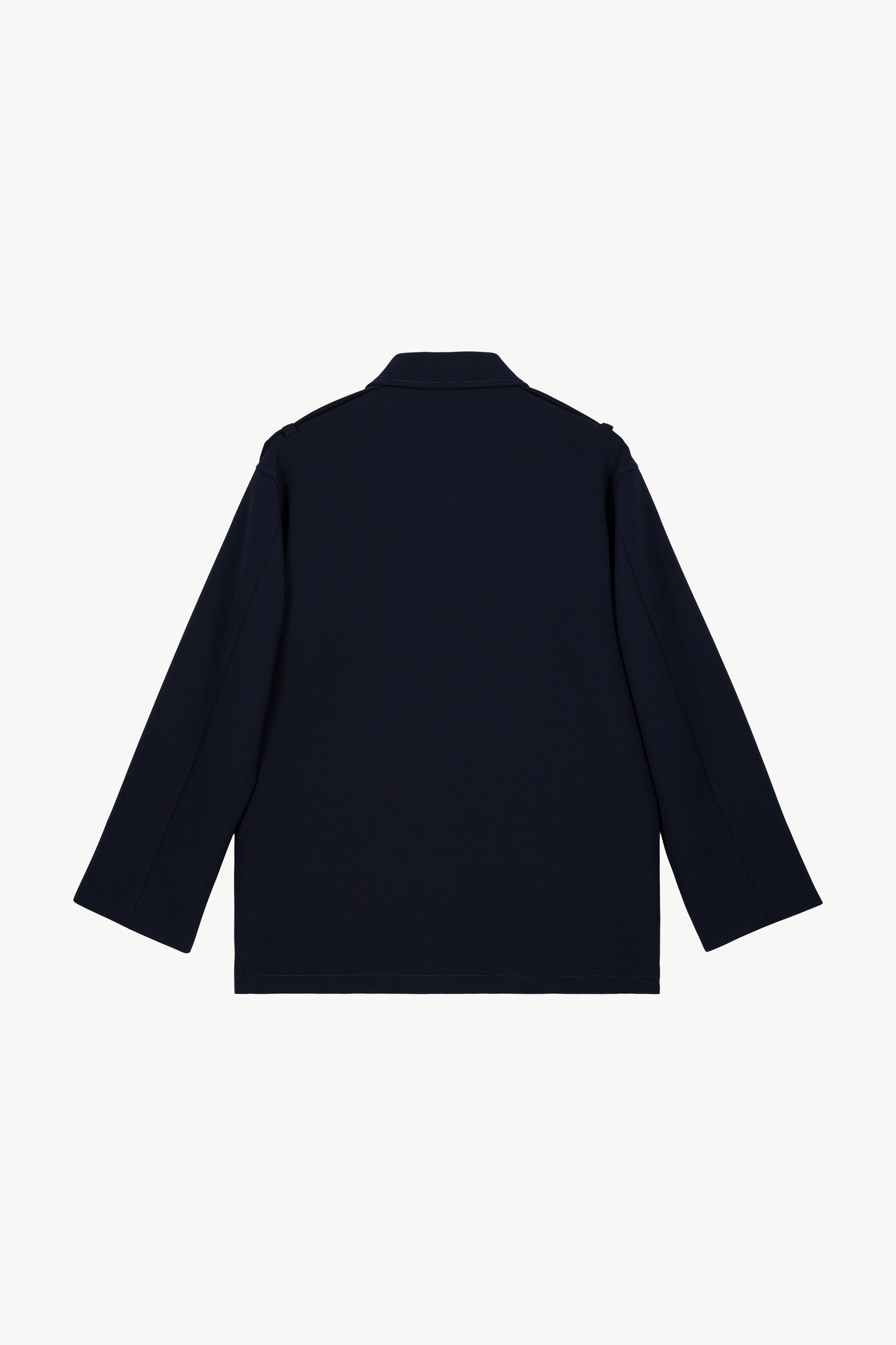 Blouson marine avec ses boutons pression gravés, ses poches passepoilées discrète