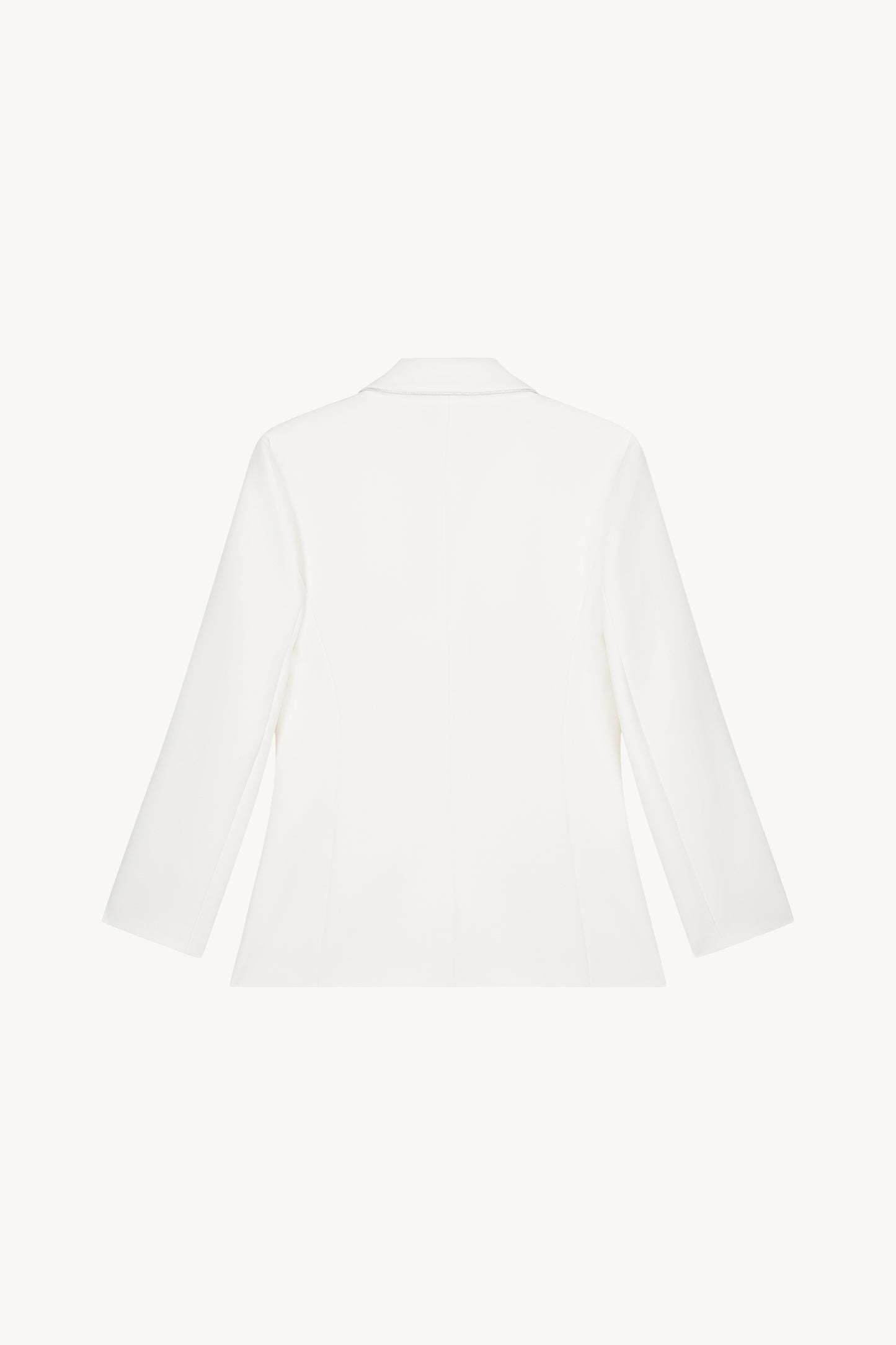 Une veste ajustée blanche cassée avec une coupe élégante, des poches à rabat et des détails raffinés.
