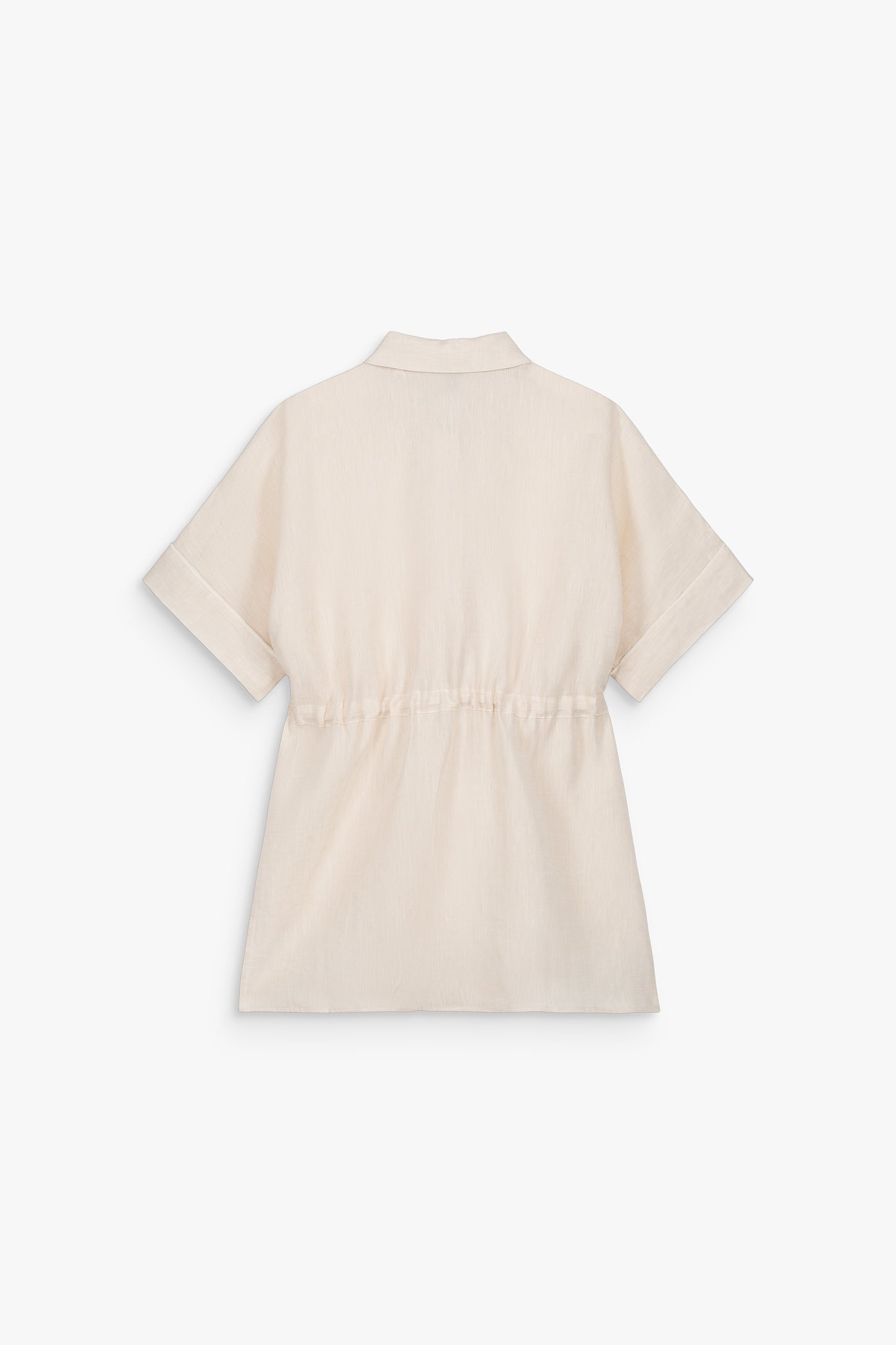 Blanc cassé et en lin, cette chemise. Sa taille cintrée par un cordon bijoux