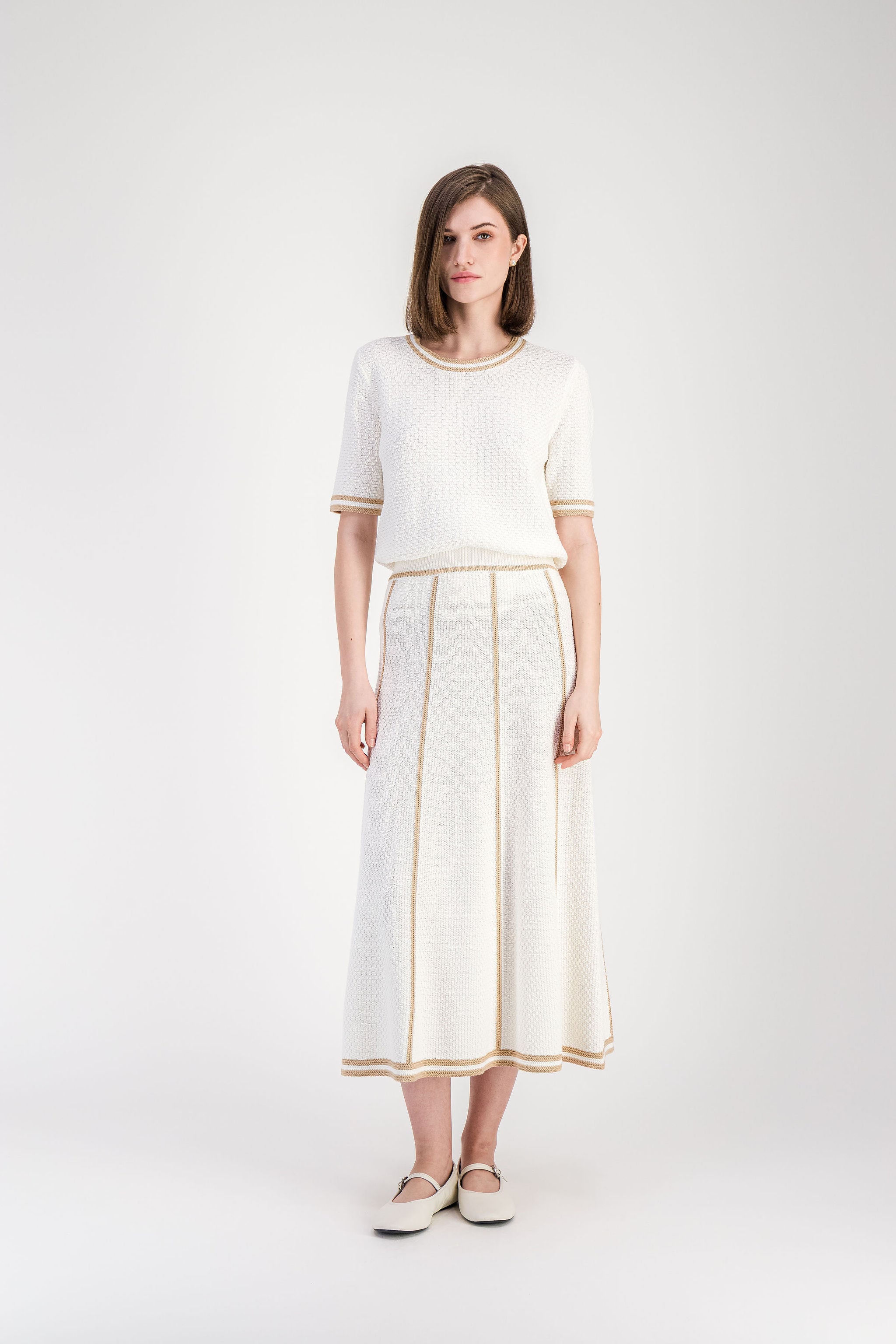 Jupe en maille coton beige avec bandes contrastées et silhouette fluide.