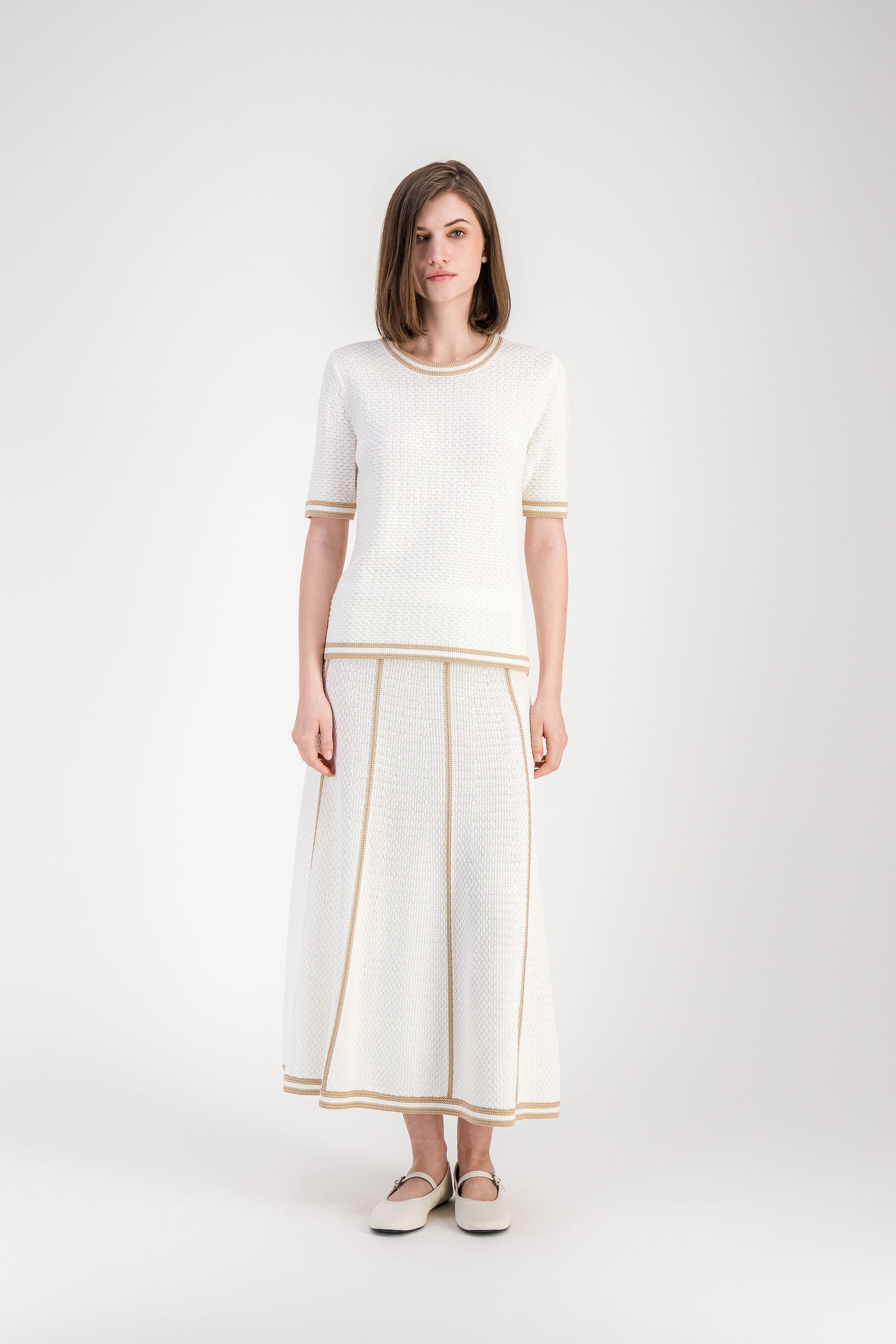 Pull léger en coton beige avec maille texturée et bordures rayées.