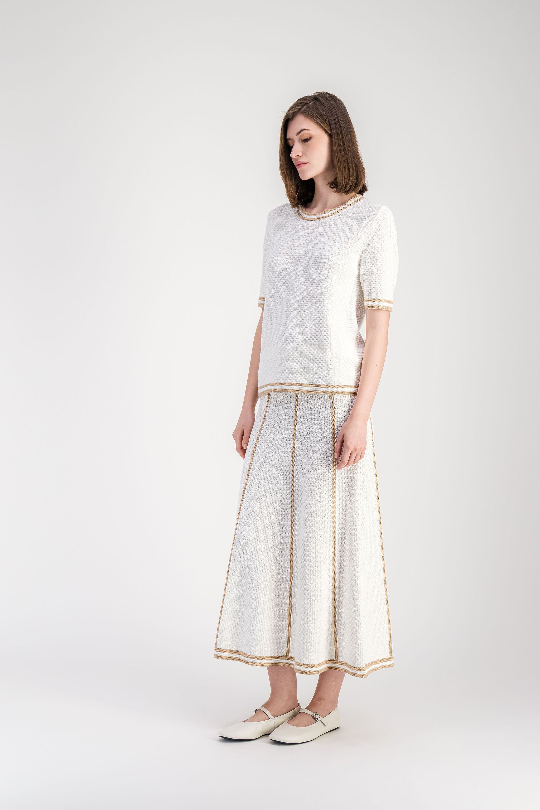 Pull beige en coton texturé avec finitions rayées au col et aux manches.