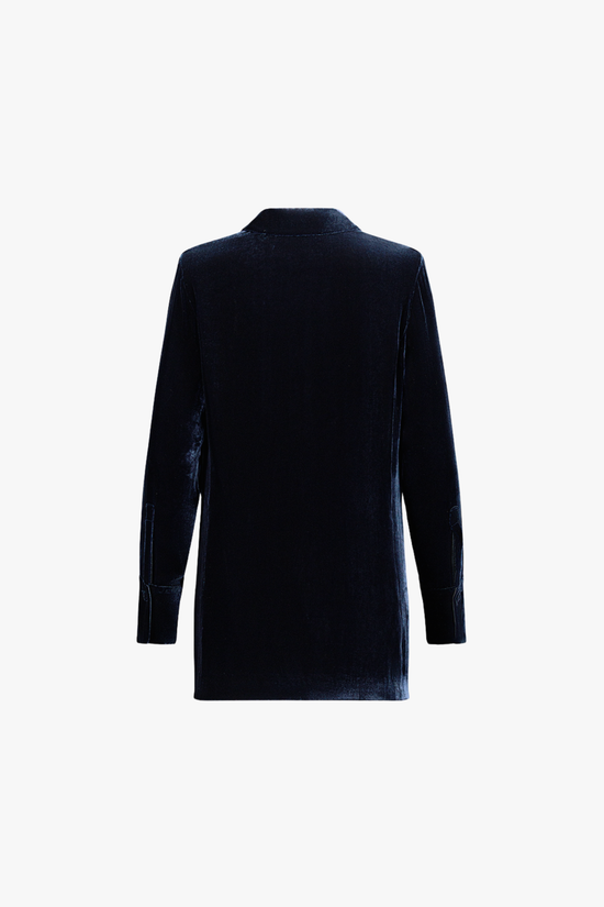 Dos de la chemise en velours marine, tombé fluide et lignes nettes.
