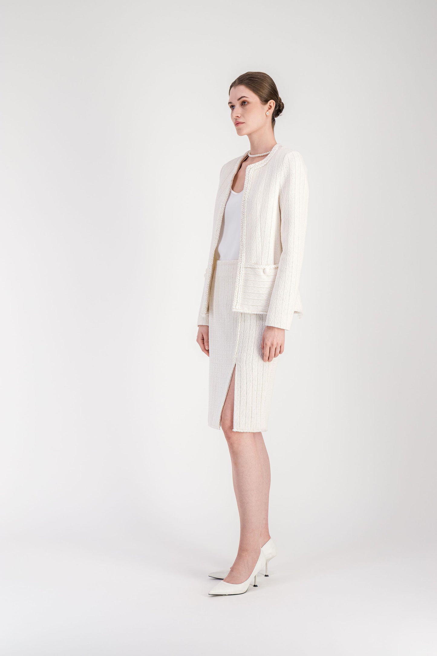 Veste élégante blanc cassé en tweed avec col rond et boutons brodés.