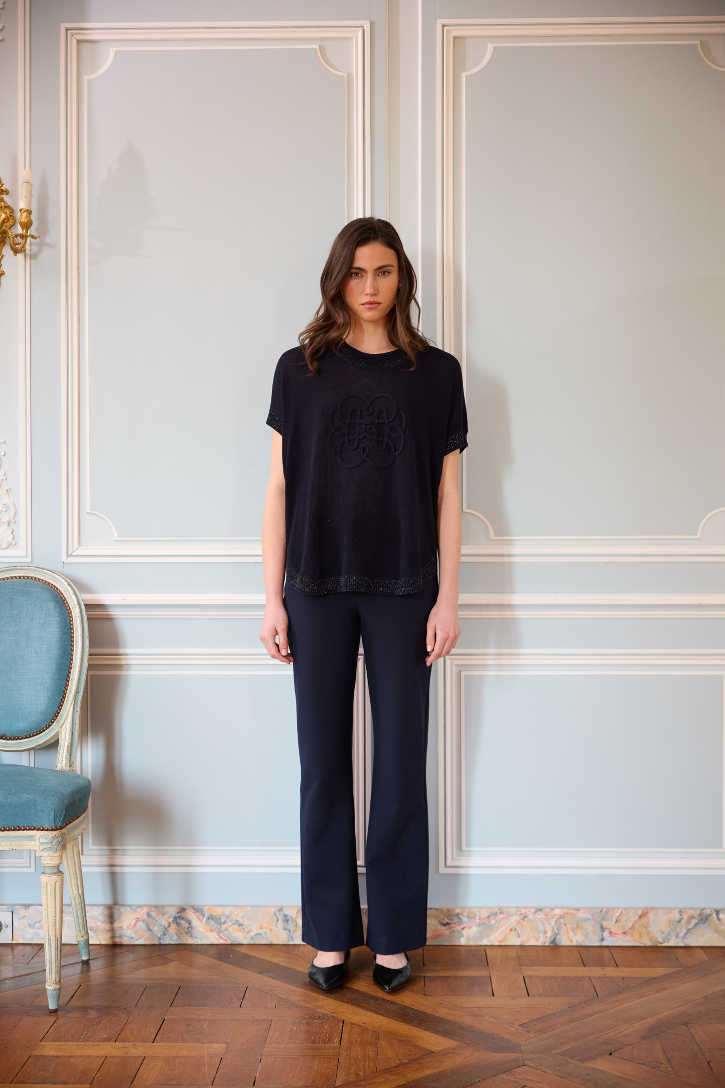 Top sans manches marine en maille de lin avec broderie florale centrale et encolure ronde.