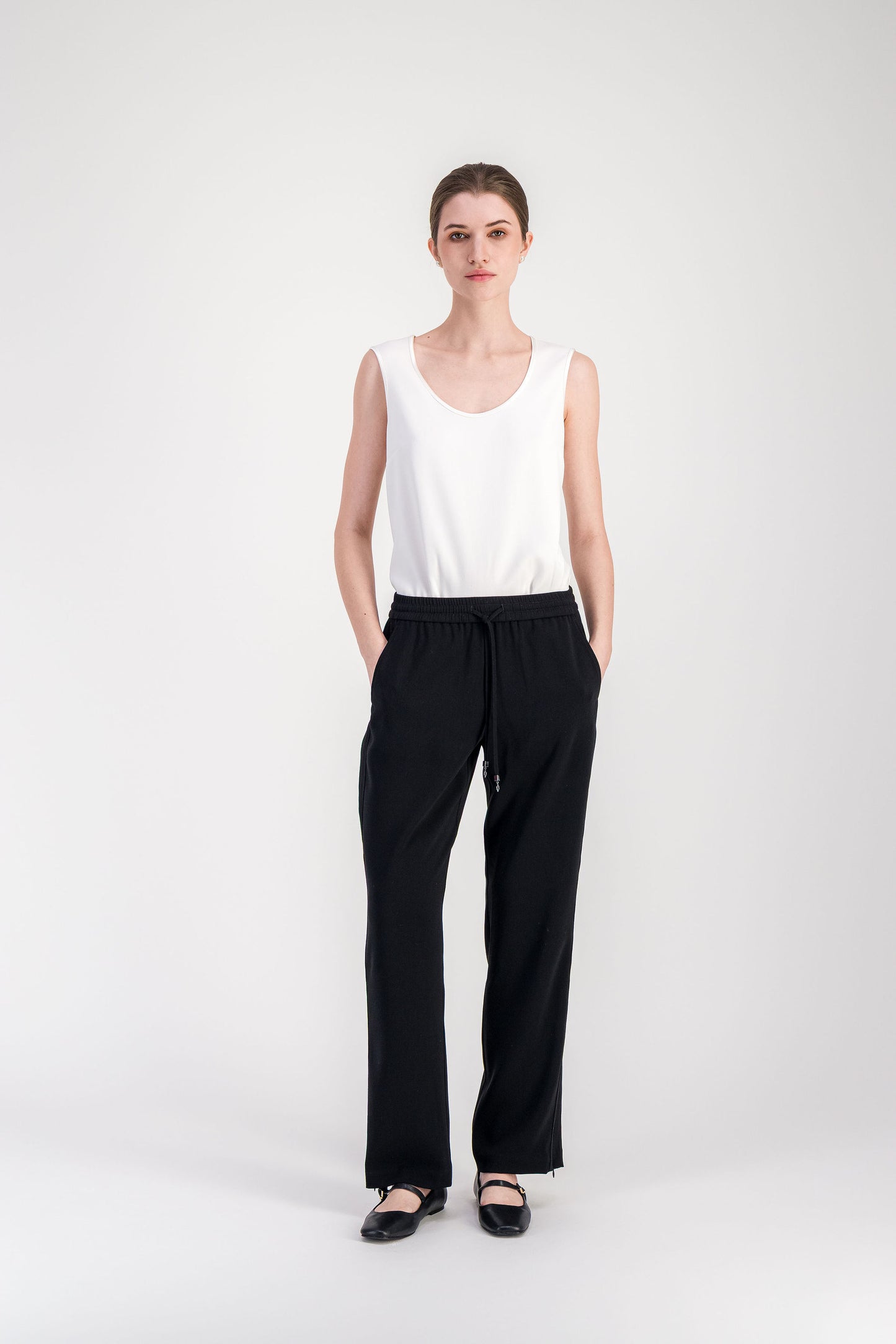 Pantalon noir coupe droite inspirée du jogging avec ligne longue et épurée.