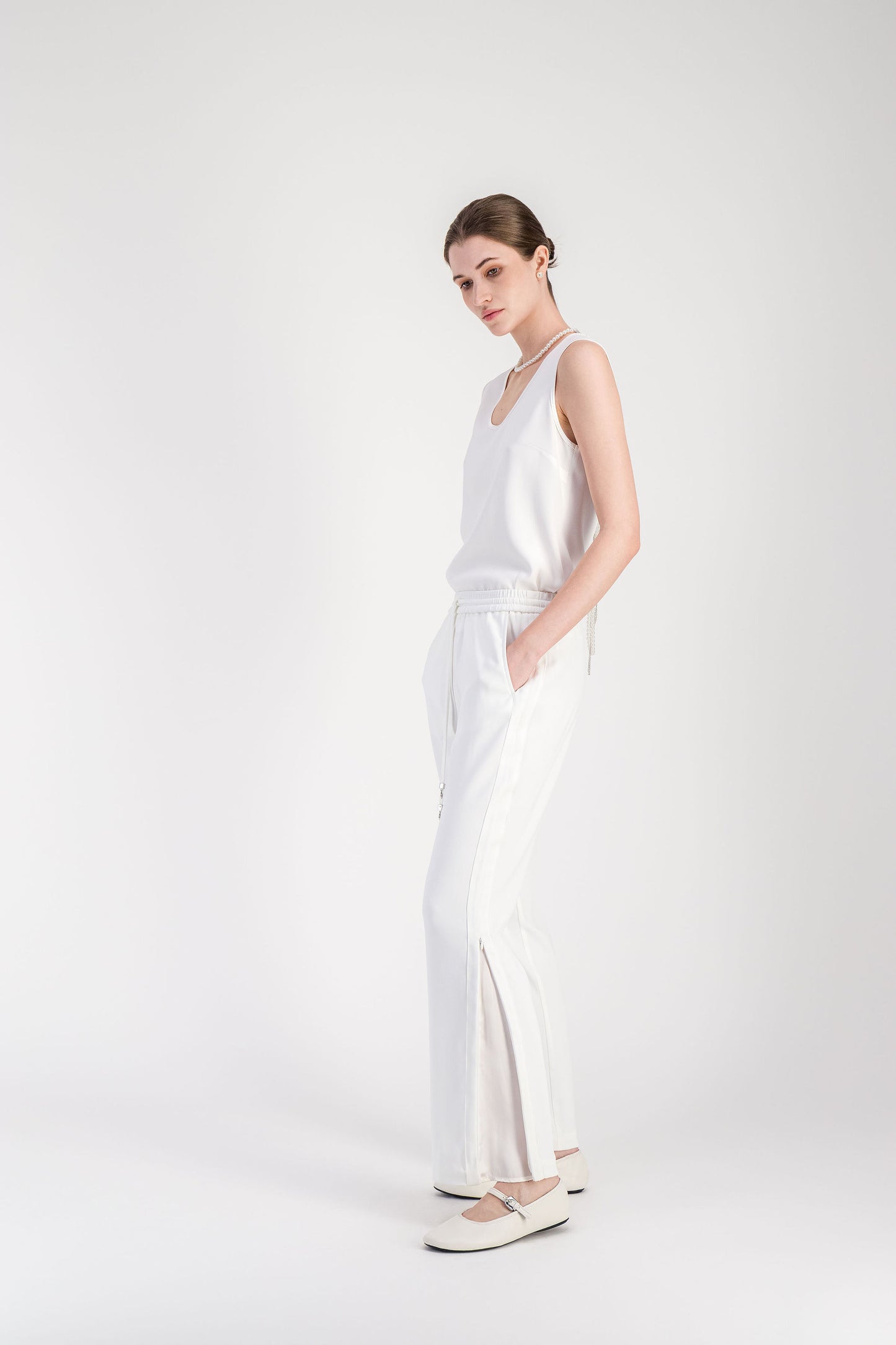 Pantalon blanc cassé à coupe droite avec taille élastiquée et tombé fluide.