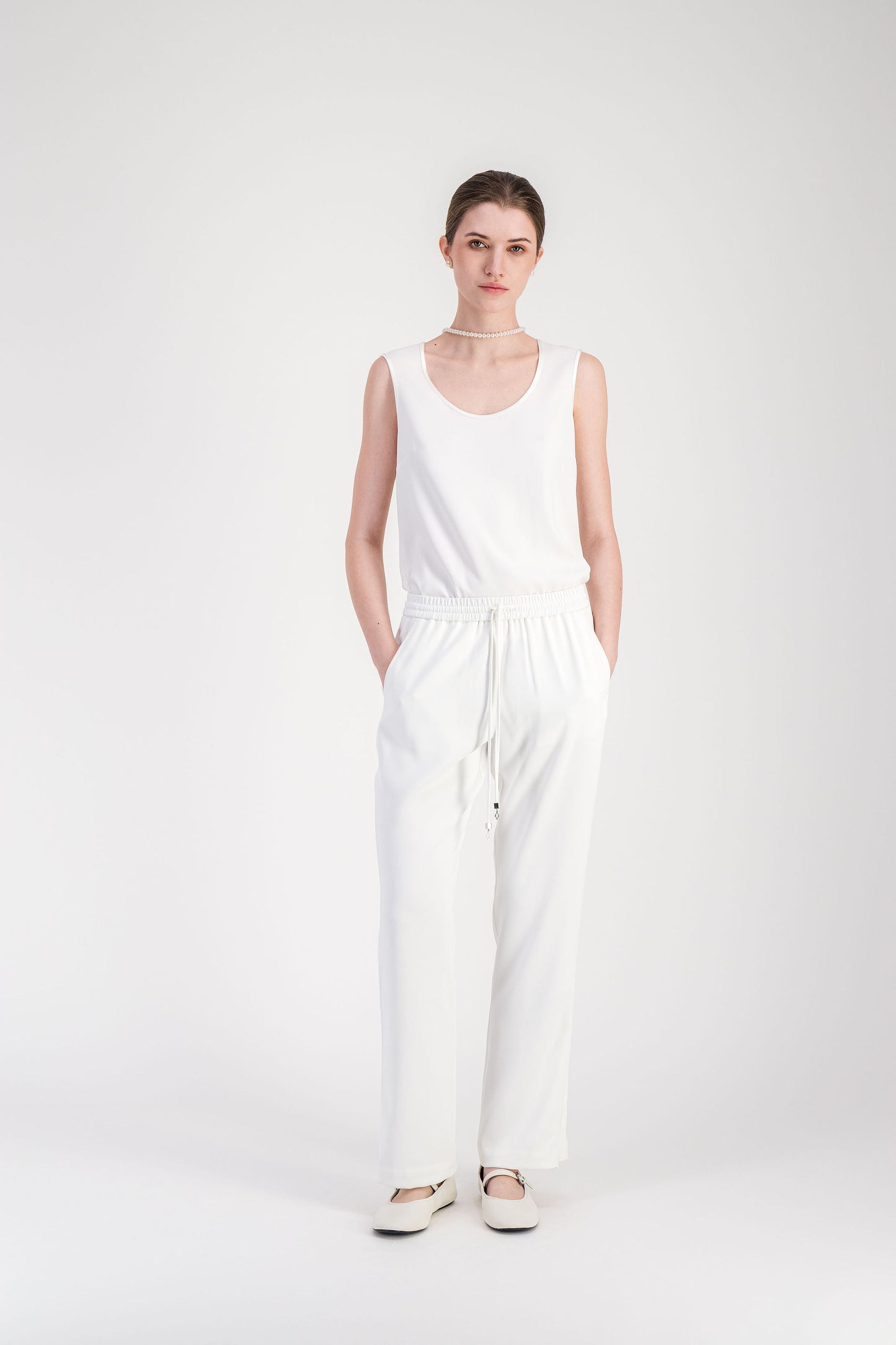 Pantalon blanc cassé coupe droite inspirée du jogging avec ligne longue et épurée.