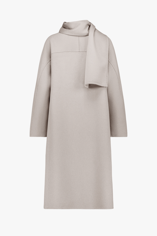 Dos du manteau long, coupe droite et surpiqûres délicates.