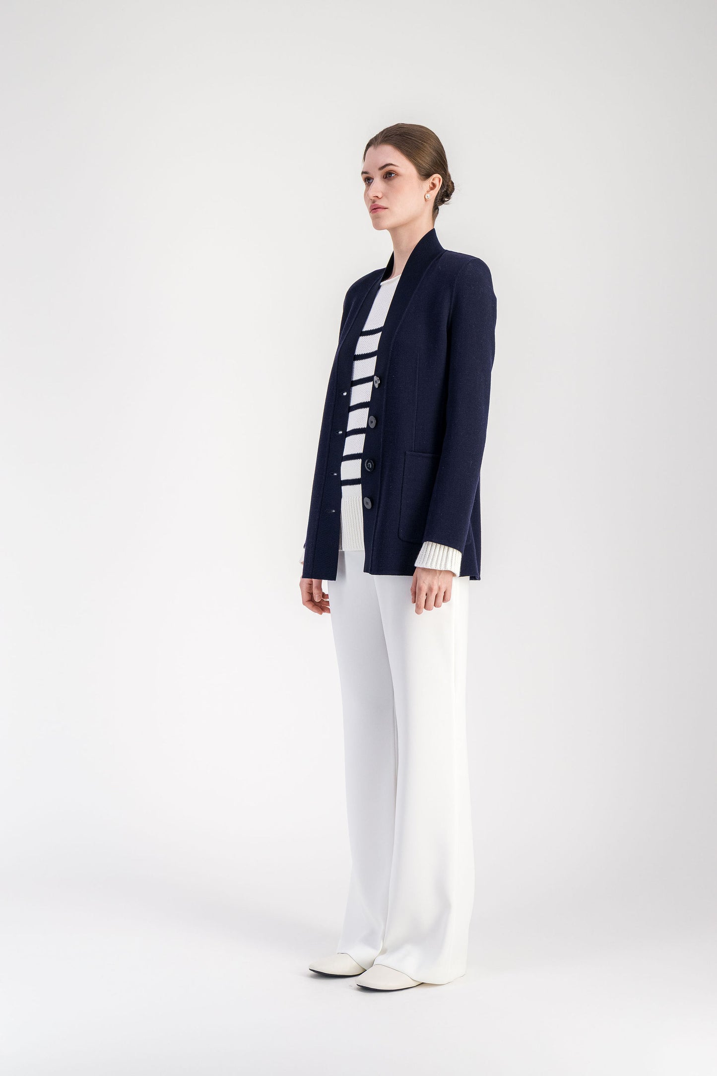 Cardigan en laine marine coupe longue, panneau avant en maille et col châle structuré, silhouette nette inspirée du vestiaire tailleur.