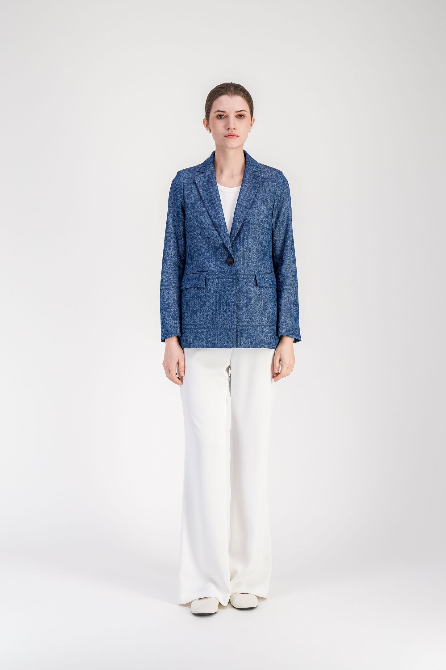 Veste bleu denim à motif discret avec col tailleur et fermeture simple boutonnage.