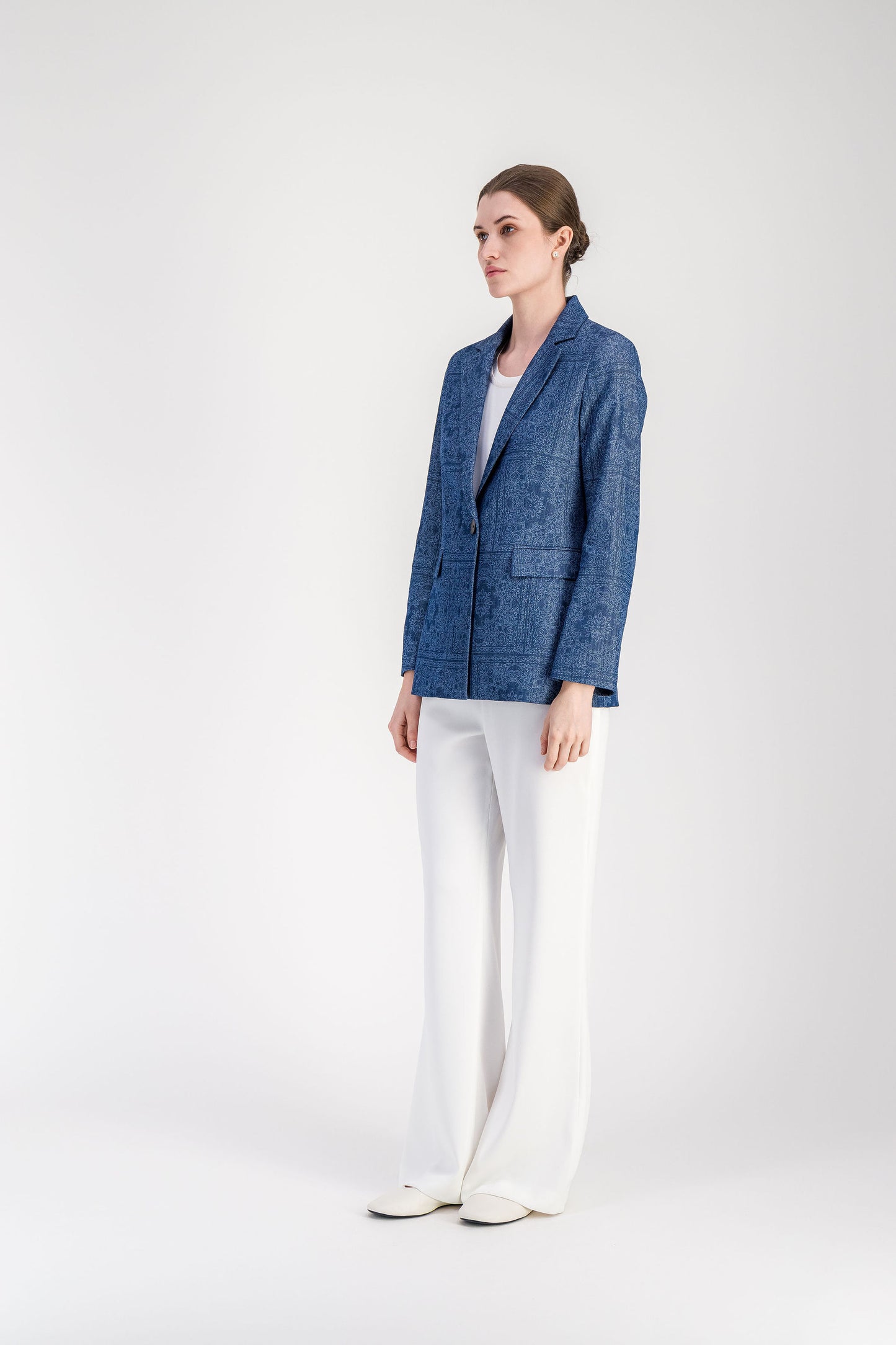 Veste femme bleu denim structurée avec col tailleur et motif ton sur ton.