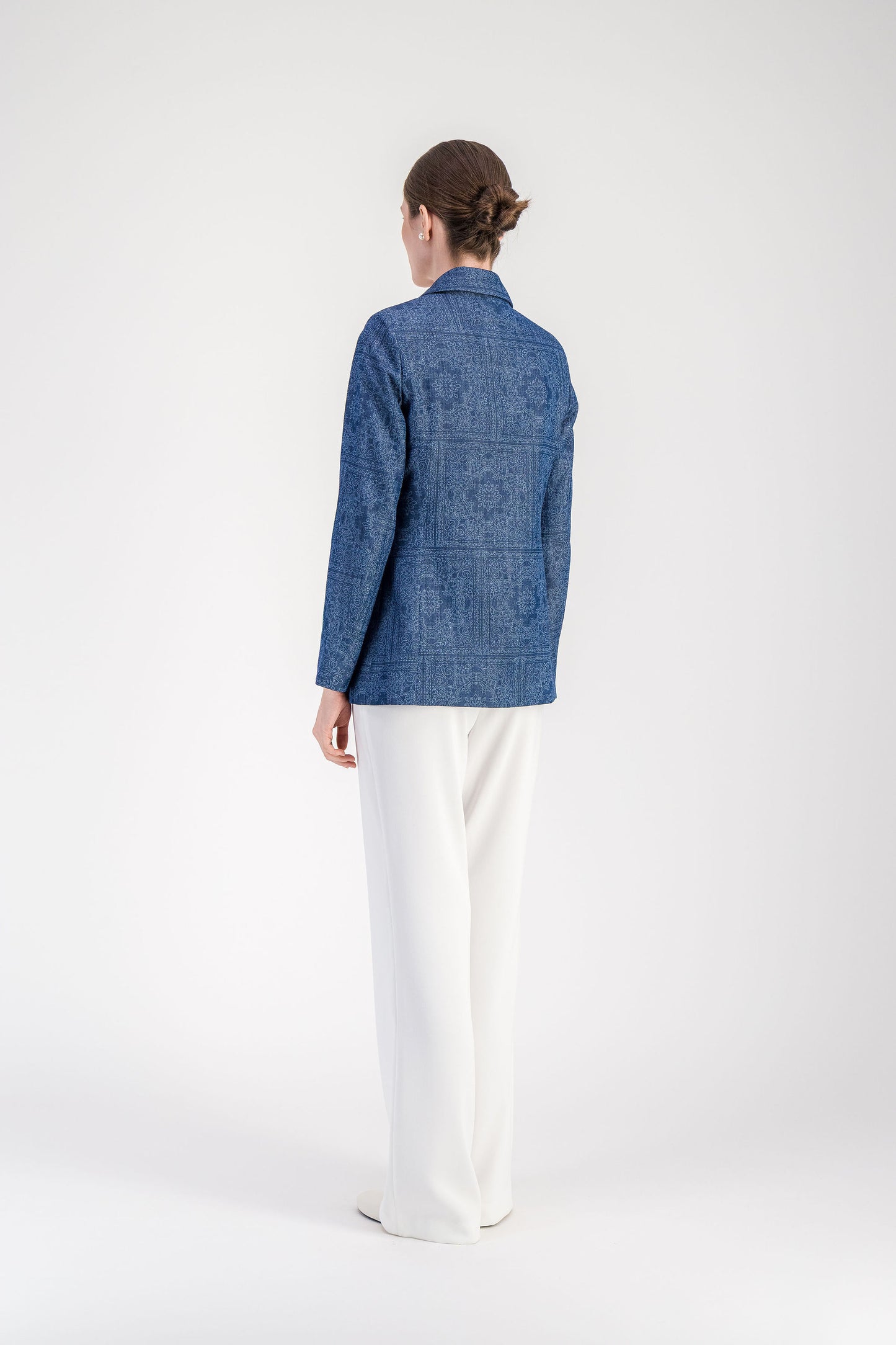 Veste bleu denim à manches longues avec fermeture à un bouton et lignes épurées.