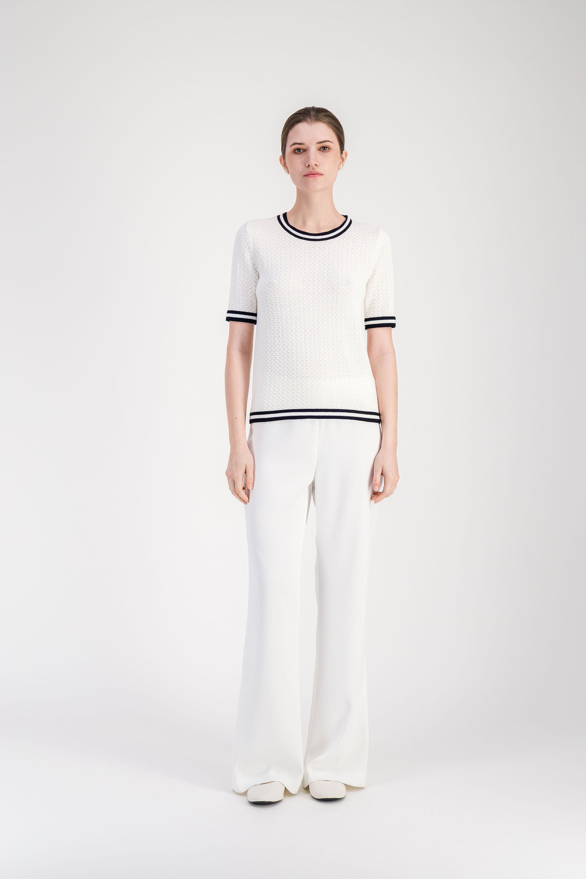 Pull léger en coton blanc avec col rond et finitions contrastées.