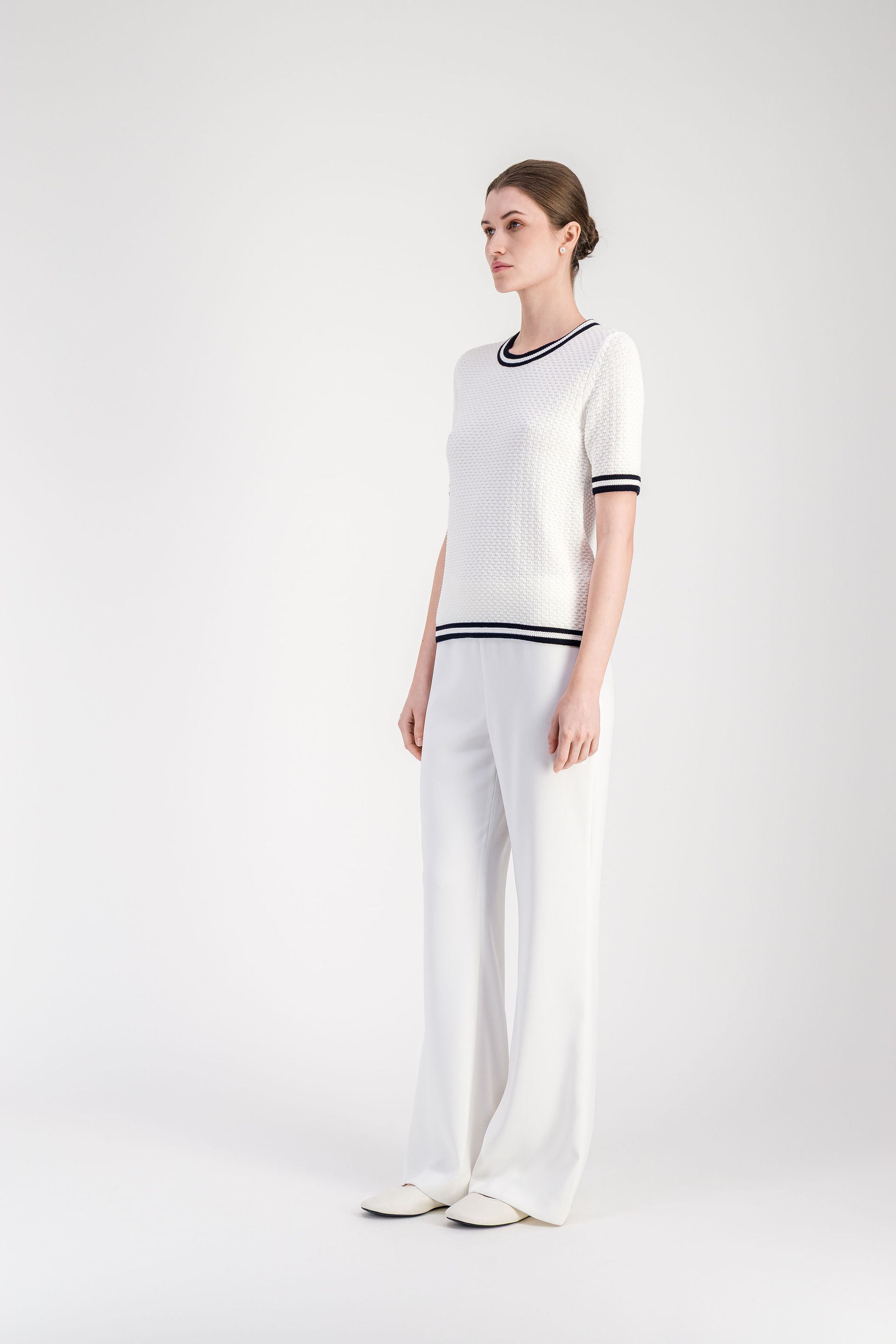 Top femme en maille texturée blanc cassé avec manches courtes.