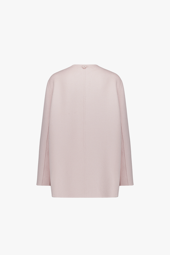 Dos du manteau rose pâle, ligne fluide et épurée.