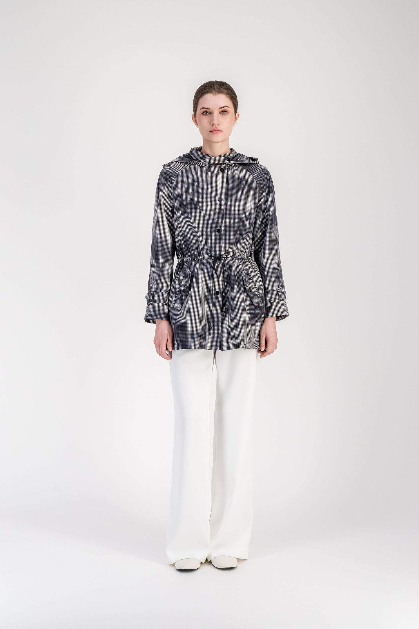 Parka vichy noir et blanc avec capuche intégrée et ligne droite structurée.