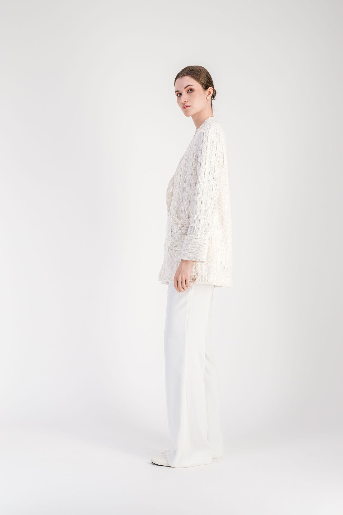 Cardigan élégant blanc cassé en tweed avec manches longues et fermeture boutonnée.