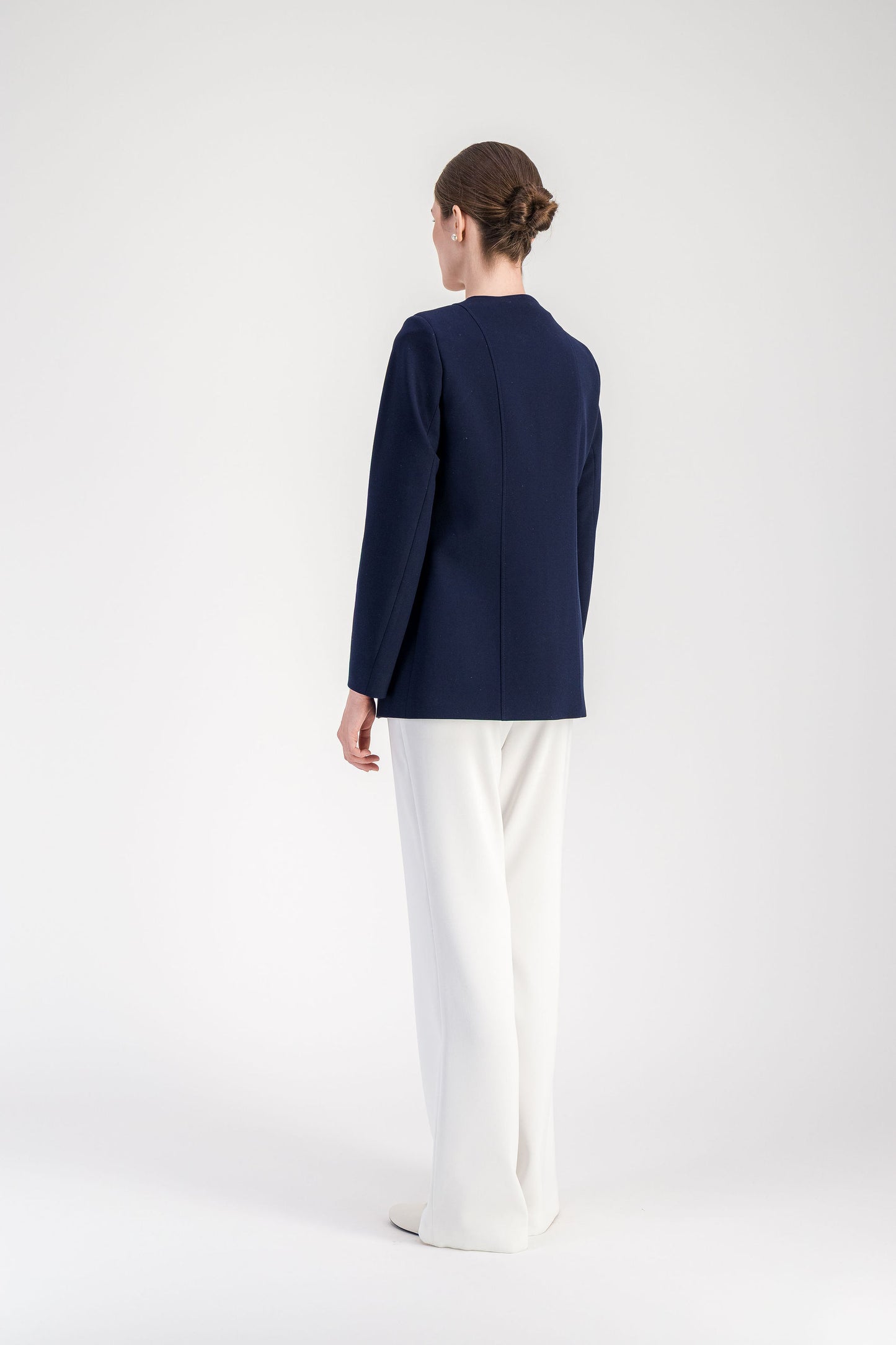 Veste bleu marine à manches longues avec col rond et boutons décoratifs.