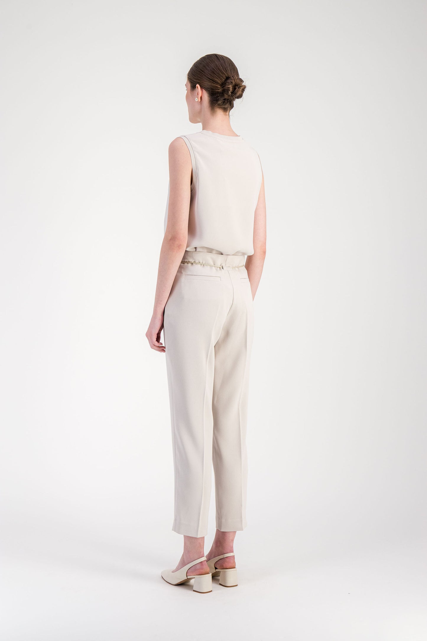 Poche latérale discrète sur pantalon fuselé beige à la construction structurée.