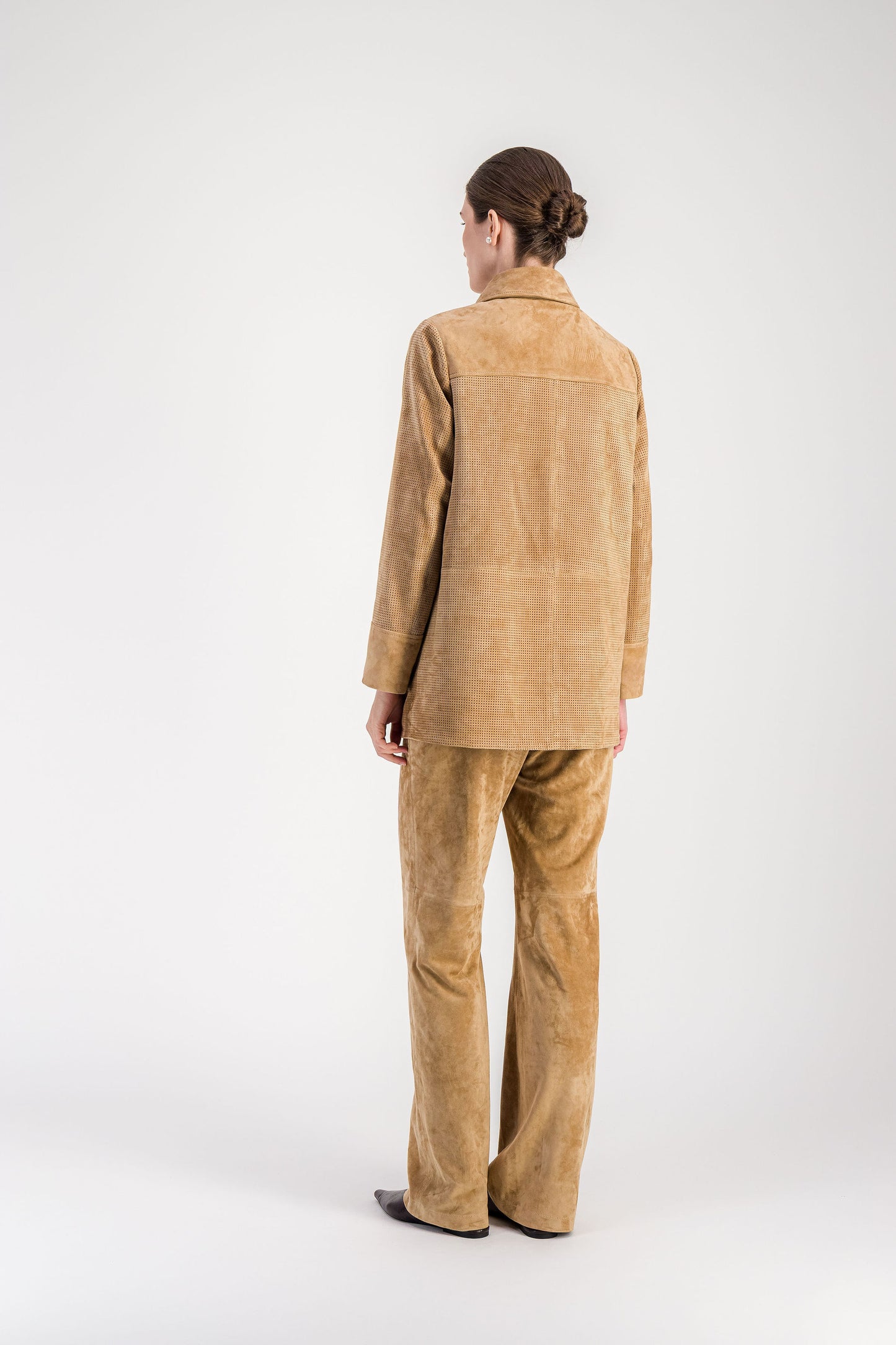 Veste en daim beige perforé avec poches plaquées et silhouette structurée.