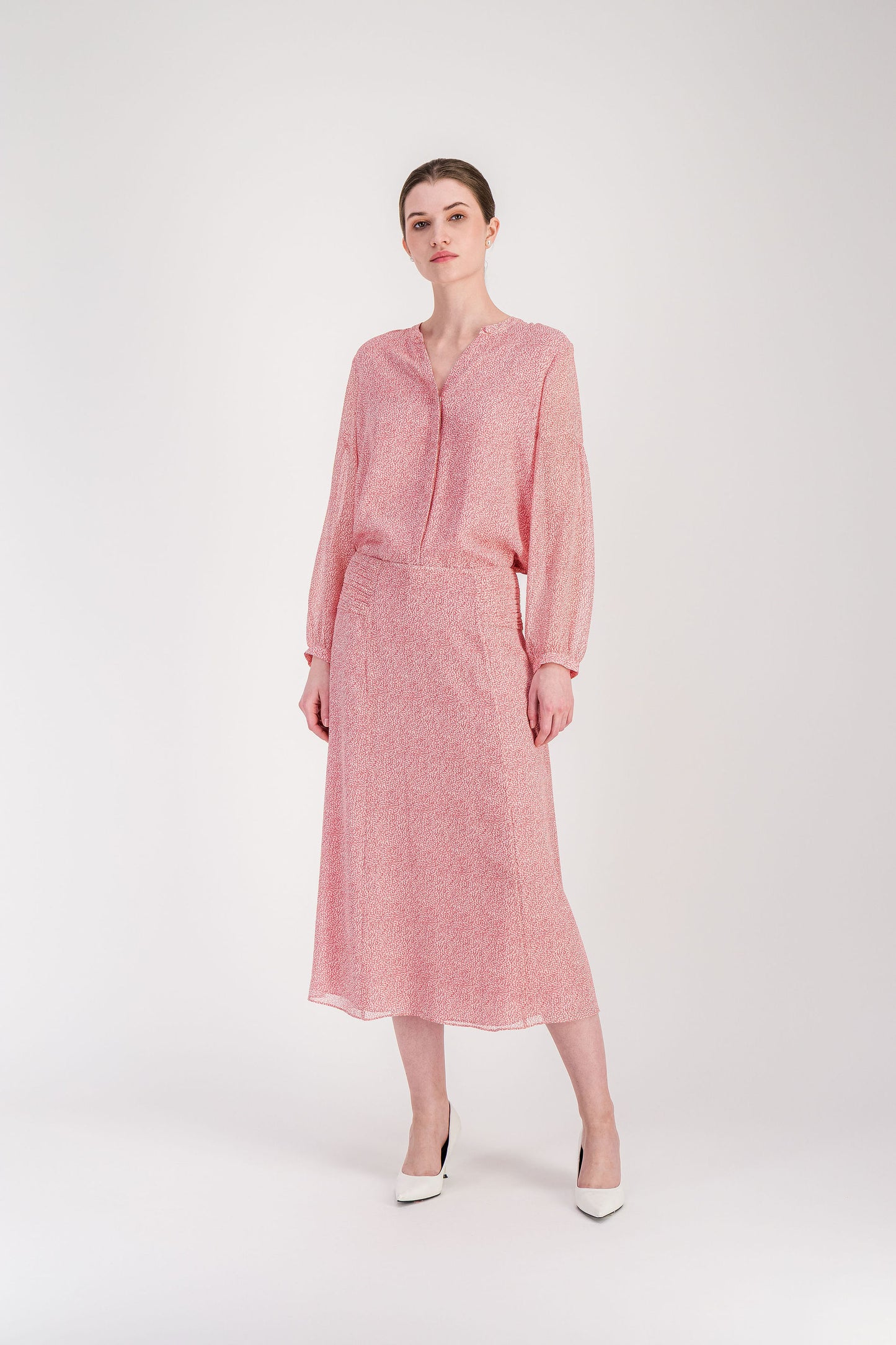 Jupe longuette en soie rose pâle avec imprimé organique et fermeture invisible au dos.