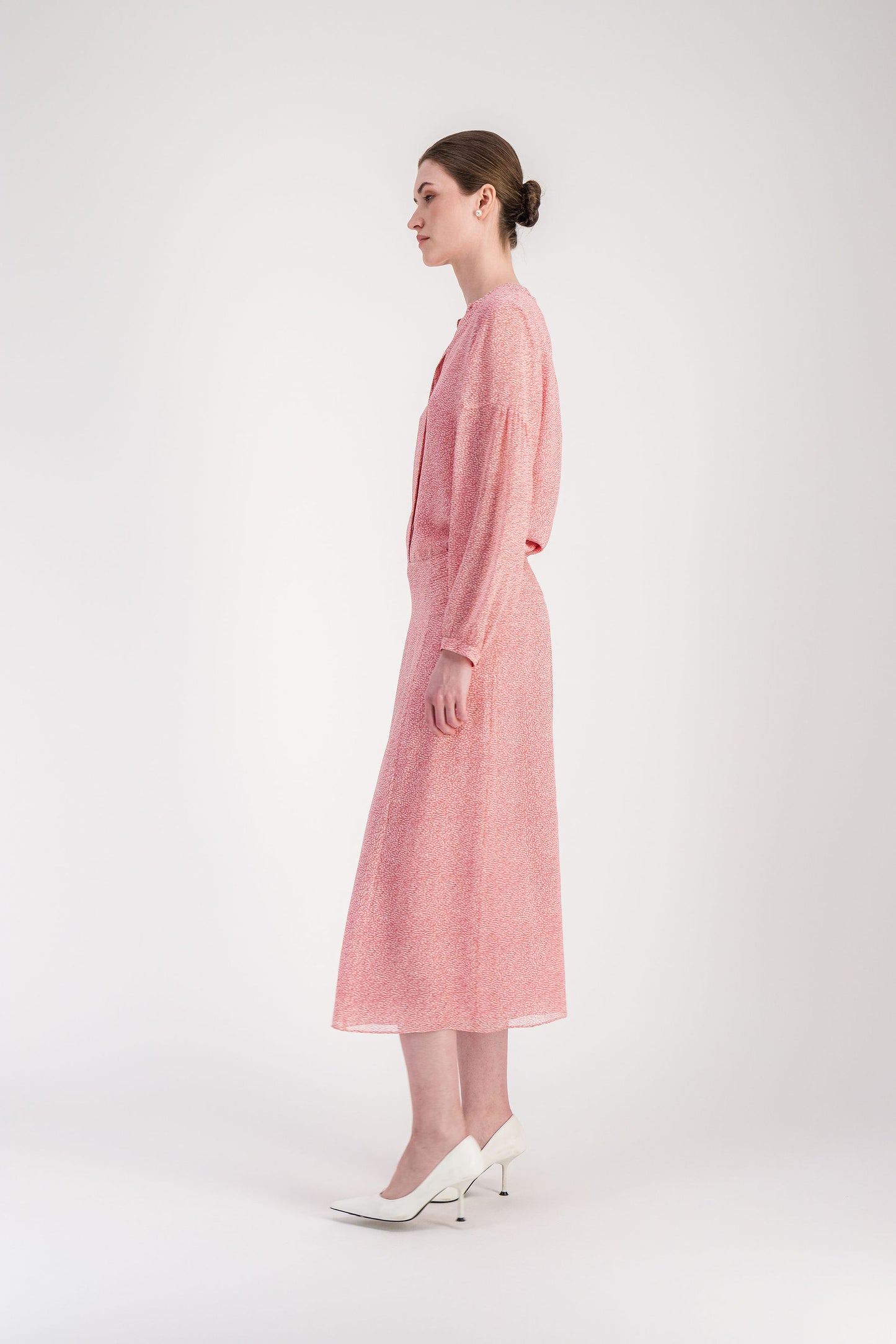 Jupe longuette en soie rose pâle avec ligne épurée et imprimé organique.