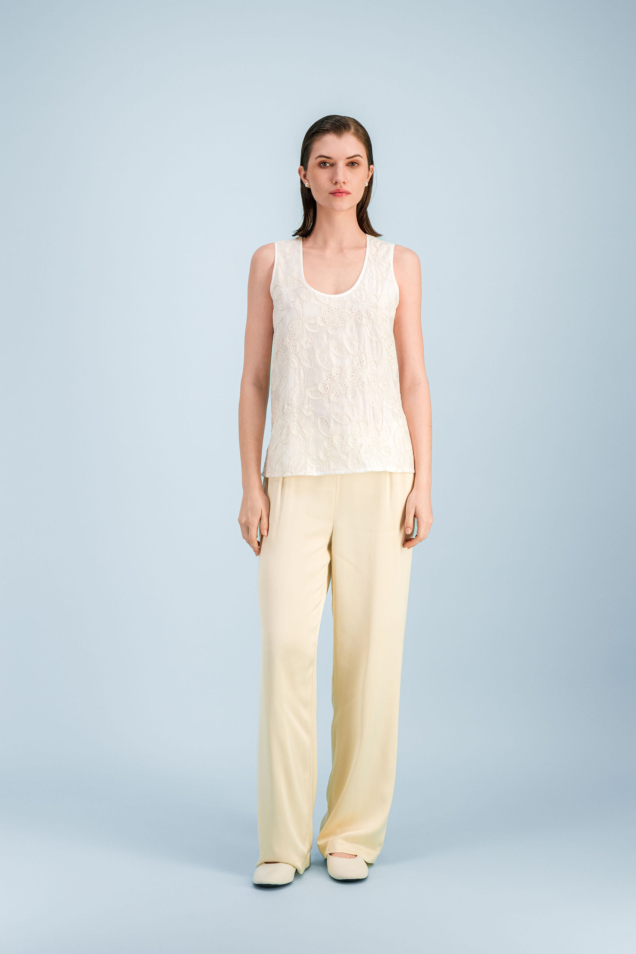 Top femme blanc cassé à broderie florale ton sur ton, coupe droite et col rond.