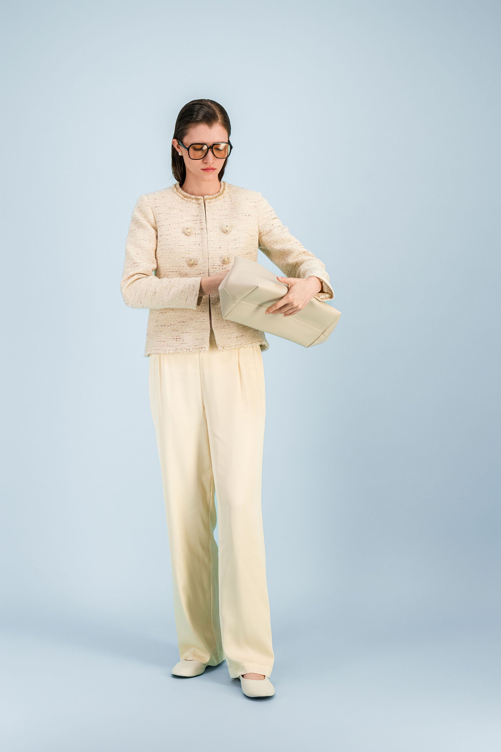Veste élégante jaune pâle en tweed avec col rond et finitions effilochées.