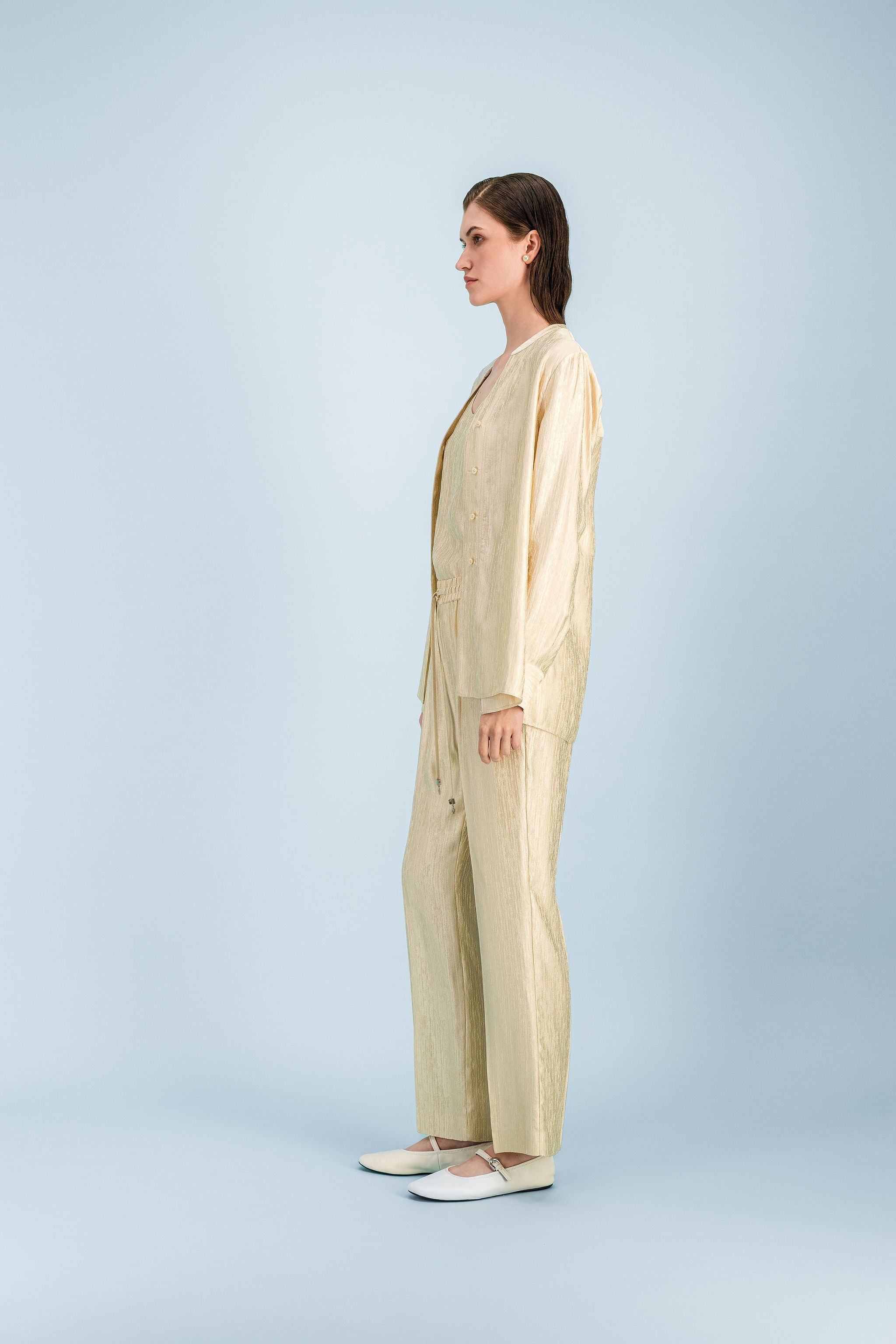 Pantalon élégant jaune clair à texture subtile et silhouette fluide.