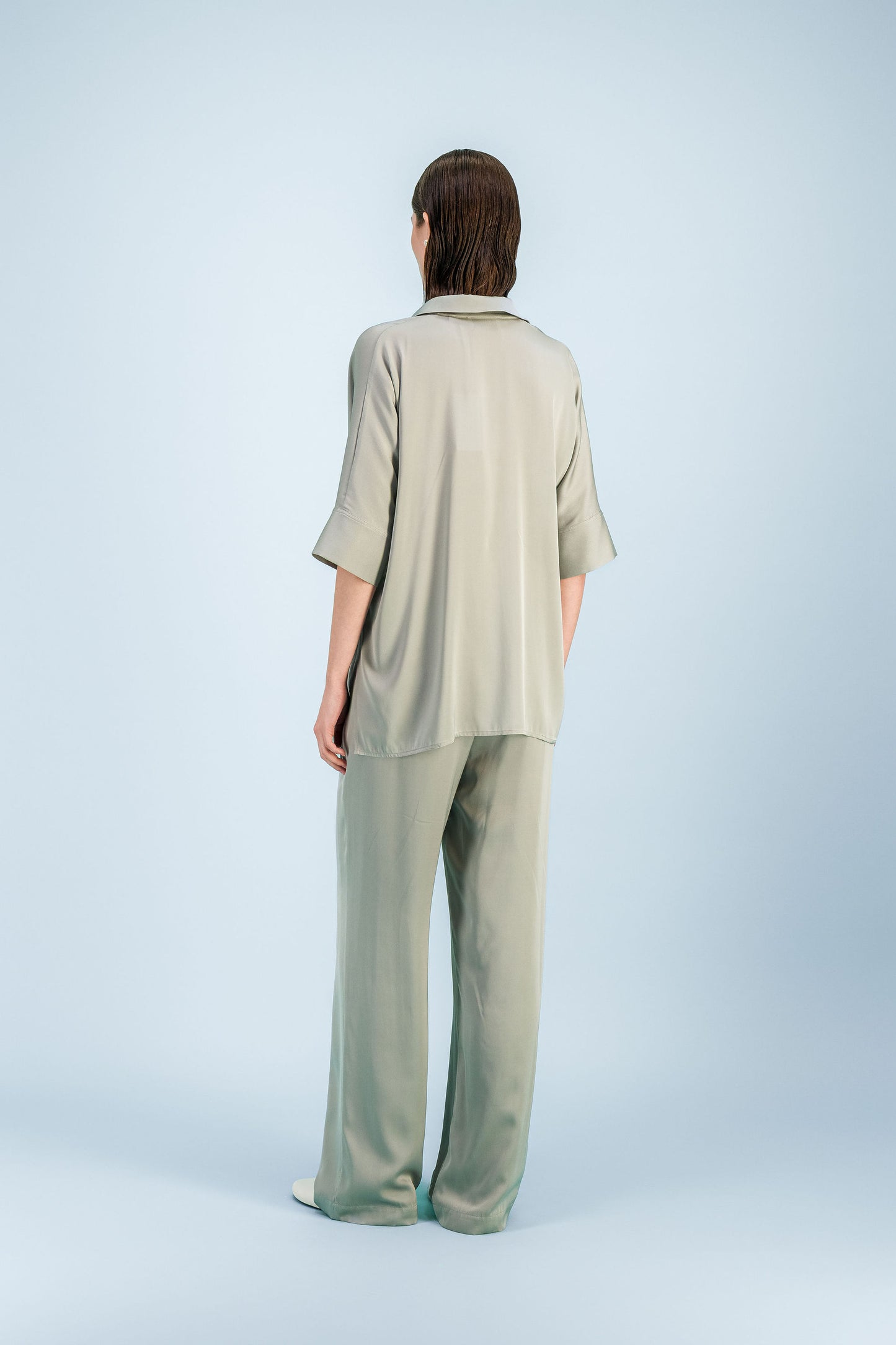 Chemise oversize en soie sauge avec boutonnage caché et ligne fluide.