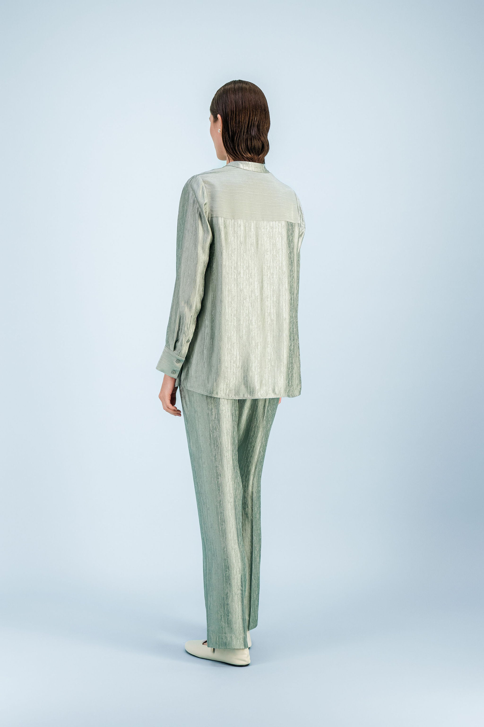 Blouse tunique vert sauge texturée avec manches longues et ligne fluide.
