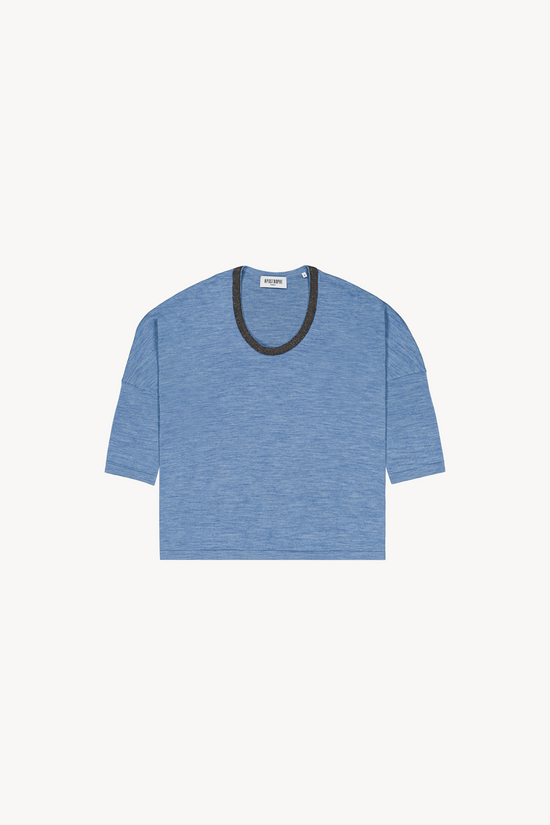 Ce pull oversize en laine mérinos bleu jean séduit par son encolure en U et sa coupe fluide.