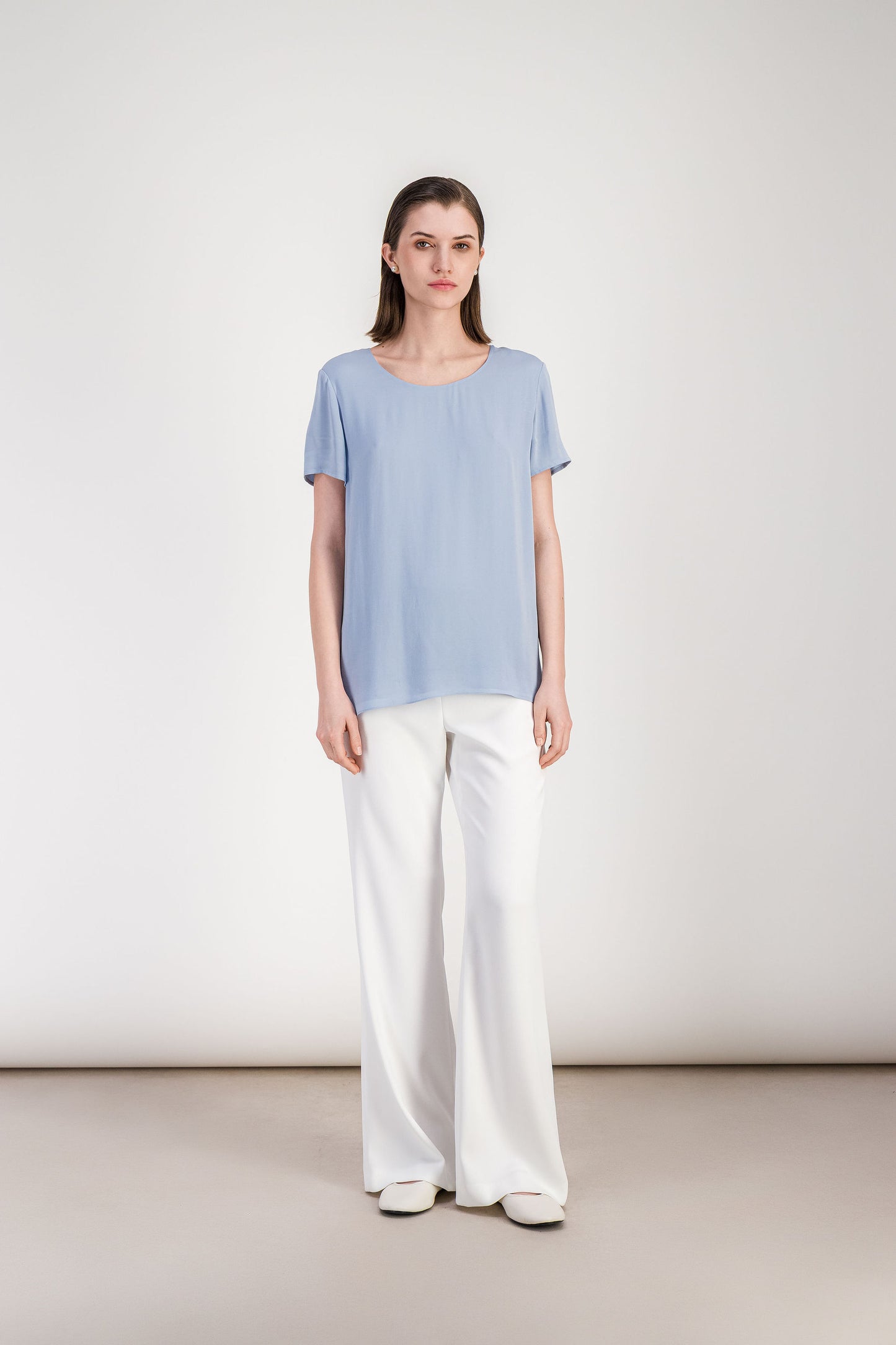 Blouse femme bleu denim à coupe fluide avec col rond et manches courtes.