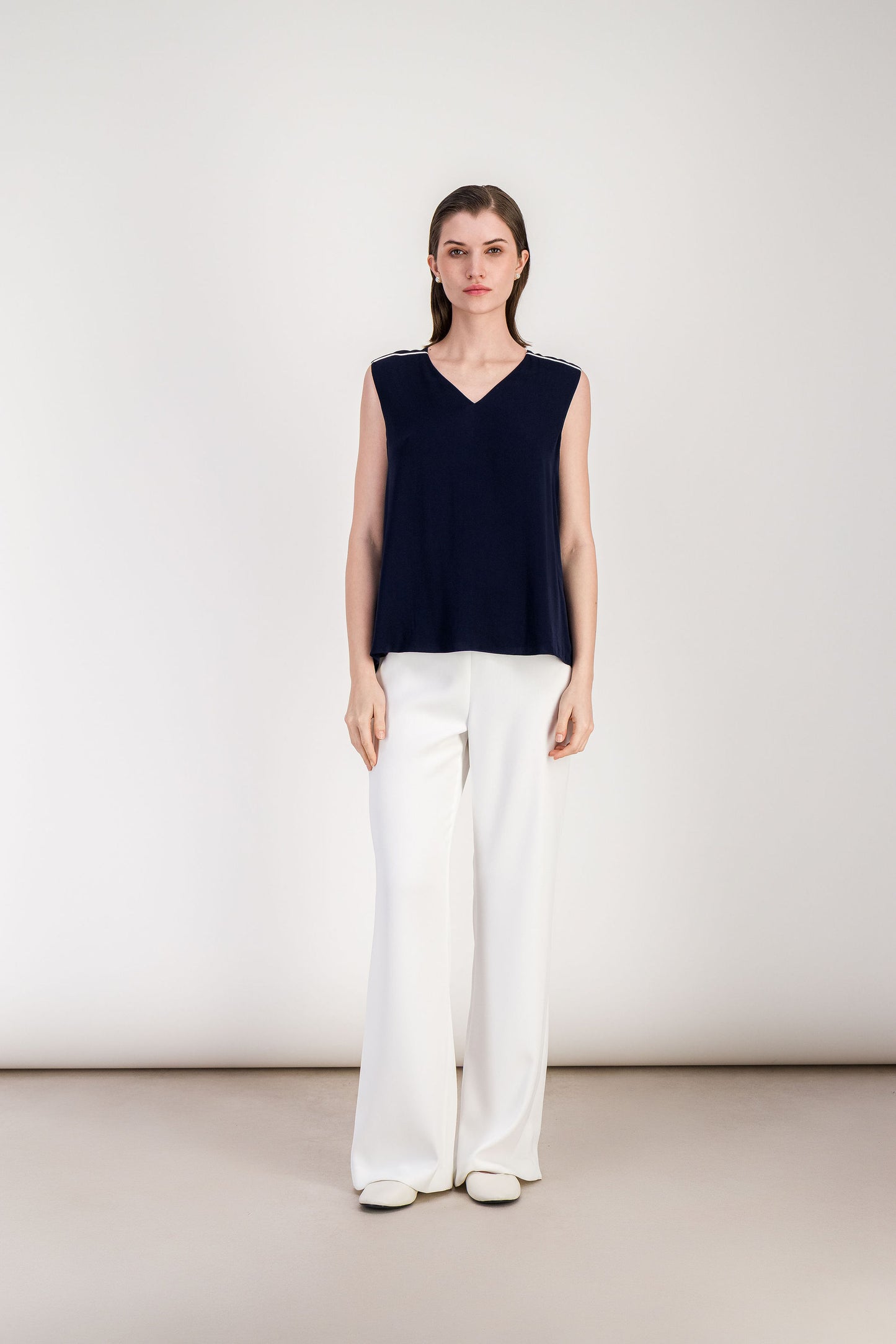 Haut femme bleu marine fluide avec encolure en V minimaliste.