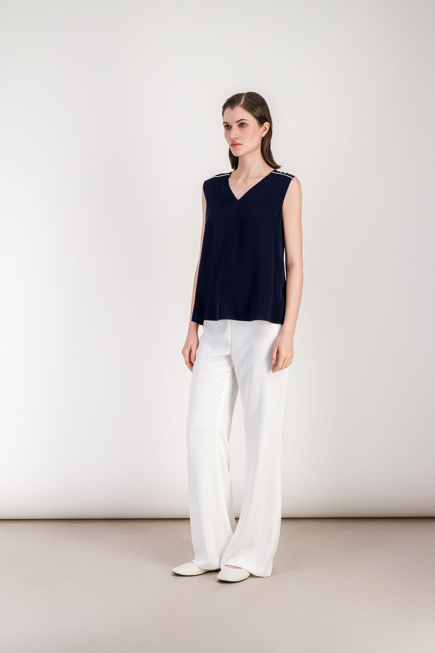 Blouse élégante marine sans manches à silhouette épurée.