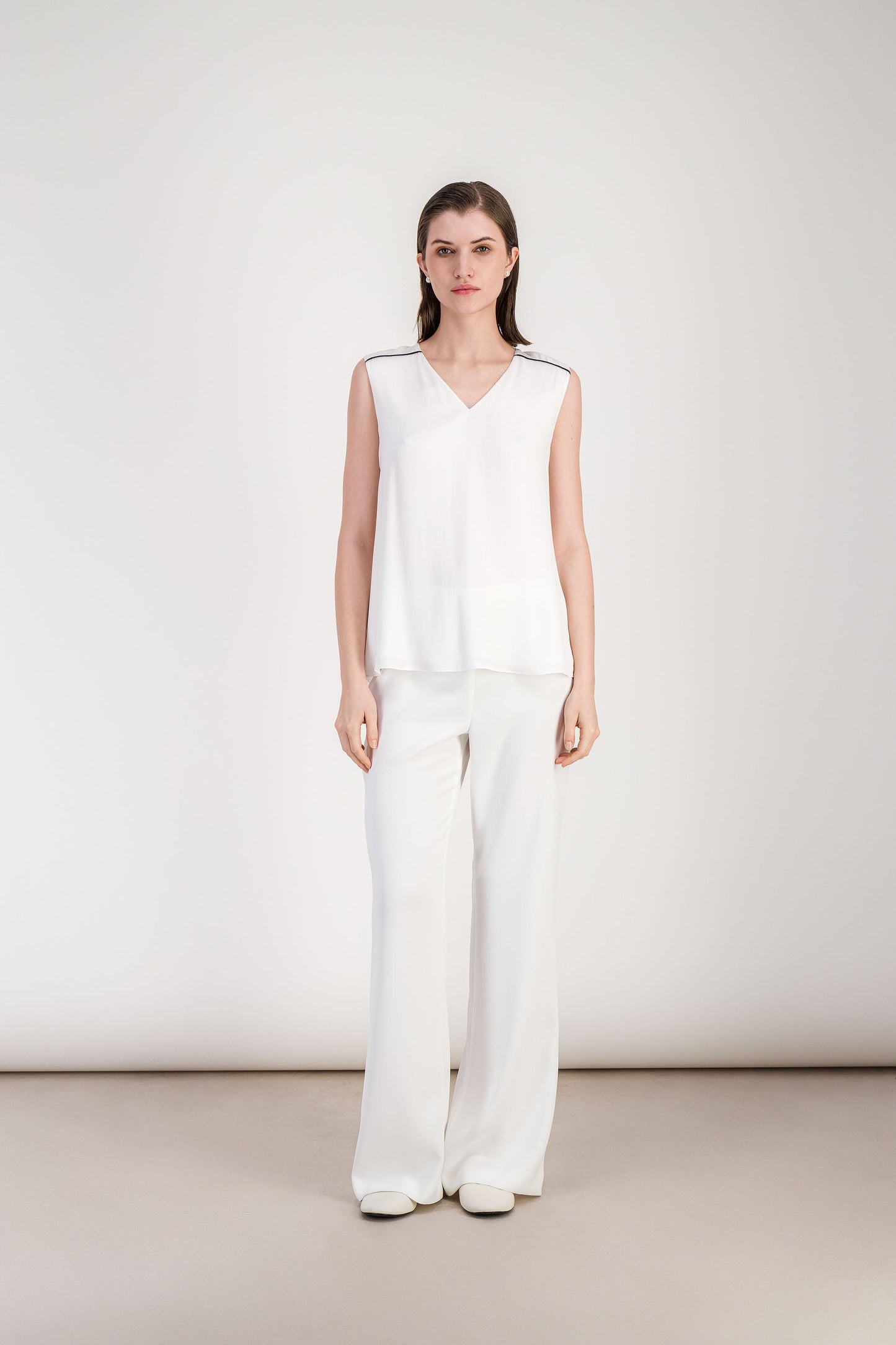 Blouse femme blanc cassé à col V avec silhouette légère et finition épurée.