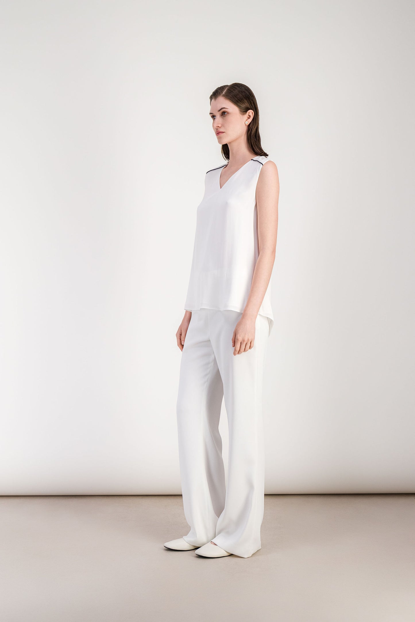 Blouse femme blanc cassé à col V avec silhouette légère et finition épurée.