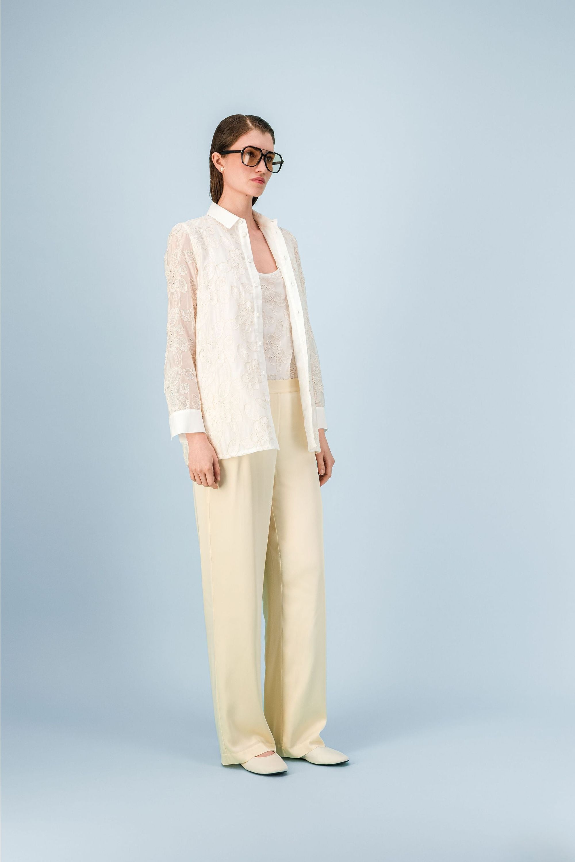 Chemise femme blanc cassé à motif floral brodé, coupe droite et fermeture boutonnée.