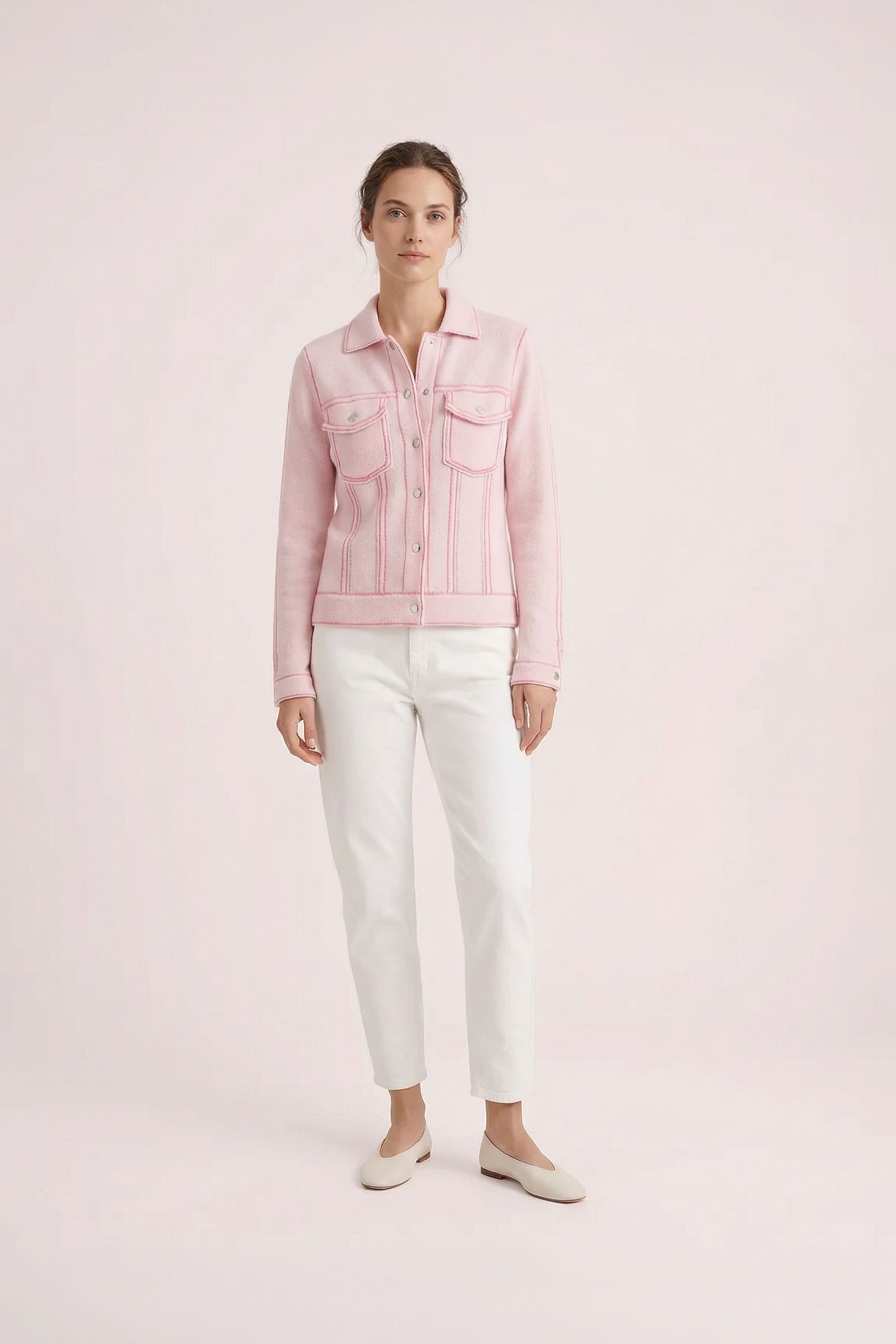 Mannequin portant une veste rose pâle structurée à col chemise et poches poitrine, associée à un pantalon blanc droit et des ballerines blanches.