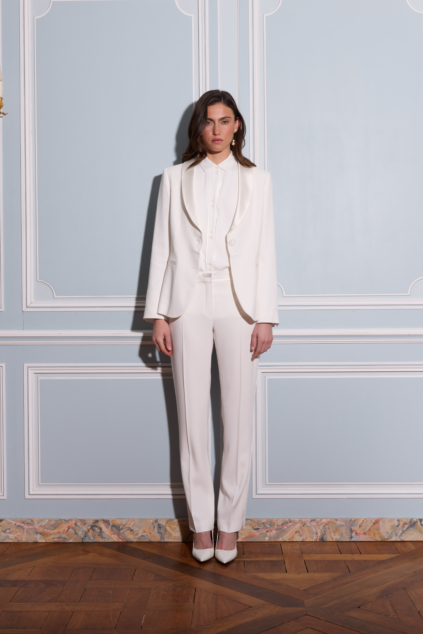 Blazer femme blanc cassé à coupe fluide avec col châle et poches passepoilées.