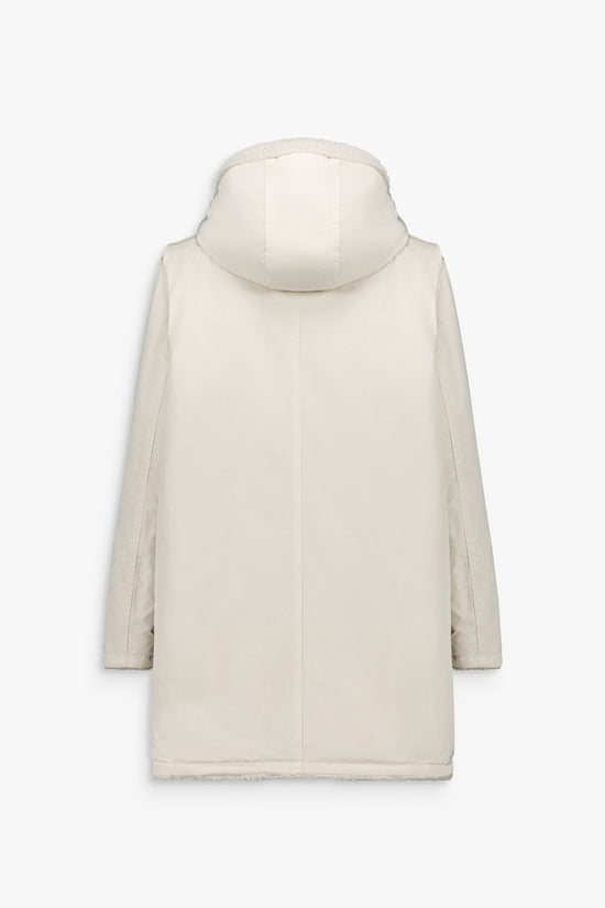 Manteau clair réversible, fourrure d’un côté, face lisse de l’autre, capuche bijoux et coupe droite.